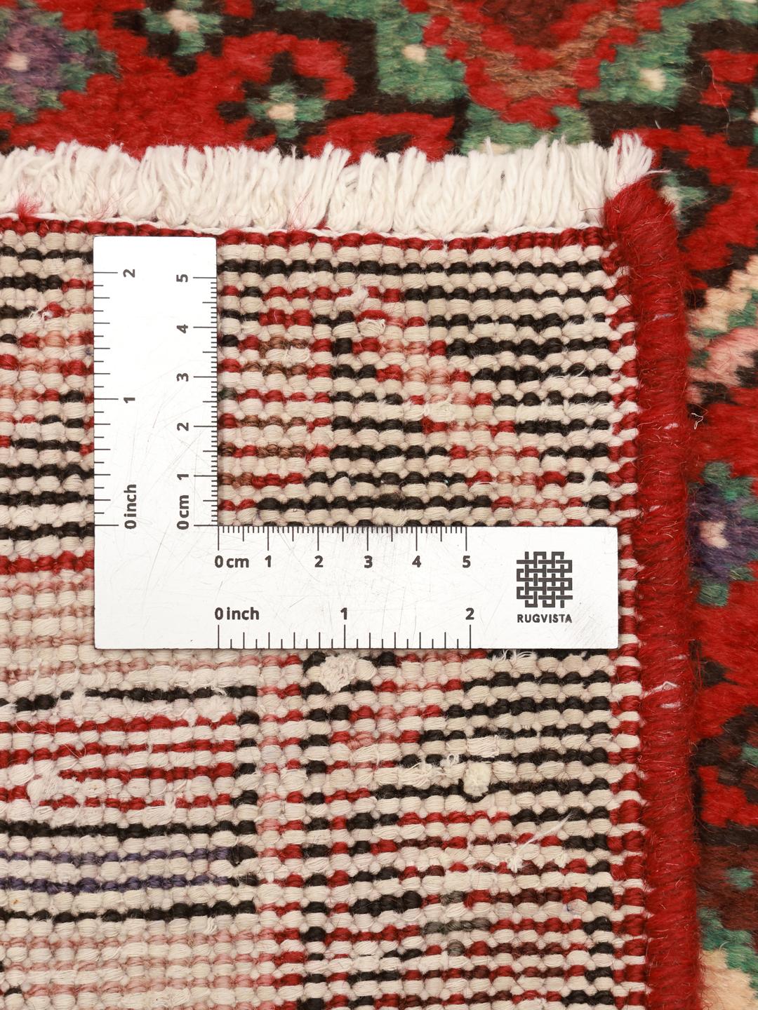 Een handgeknoopt Joshaghan-tapijt uit het Midden-Oosten in tinten rood en blauw.