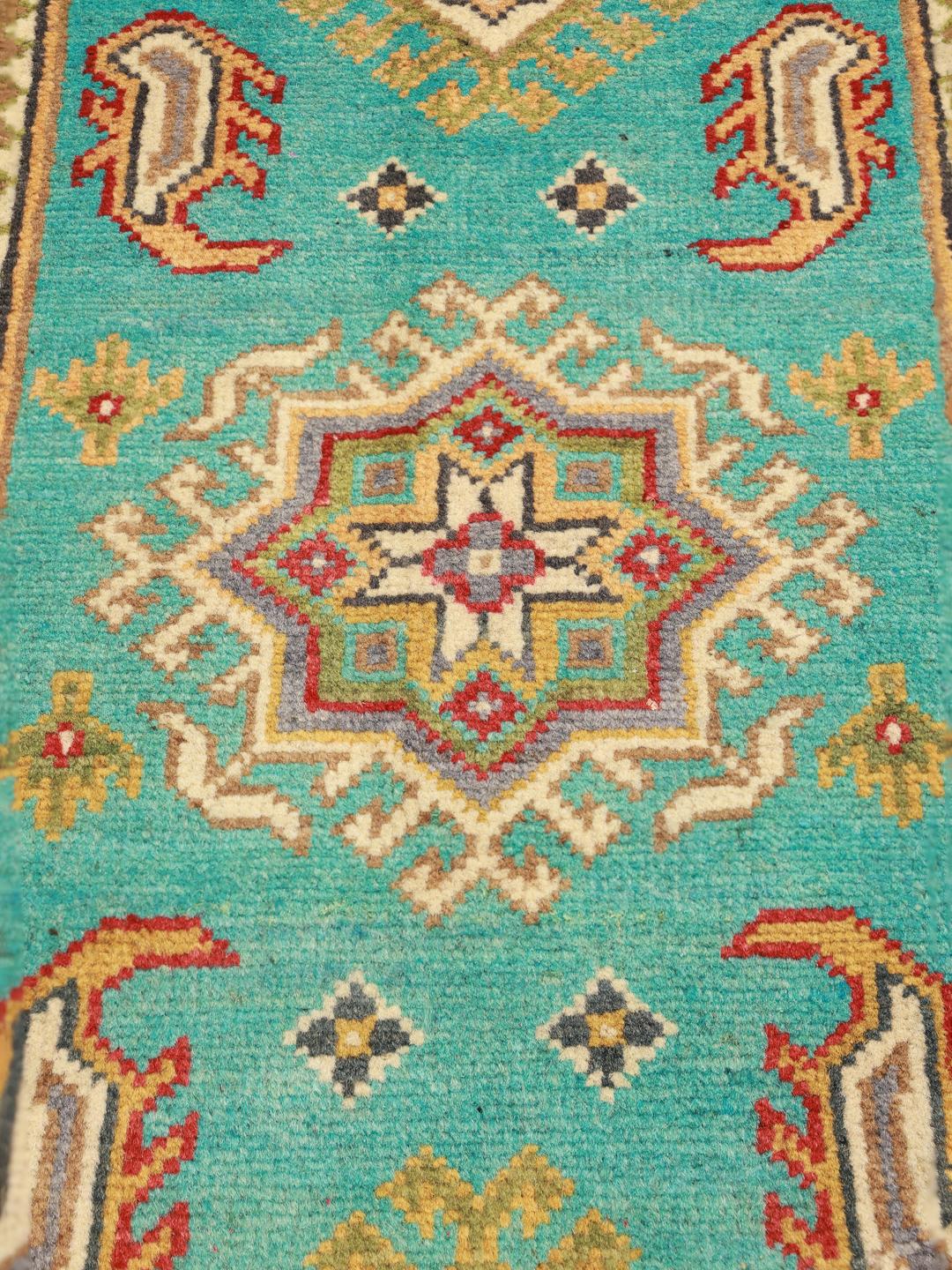 Covor Kazak afgan înnodat manual, cu un câmp vibrant de culoare teal și modele geometrice tribale.