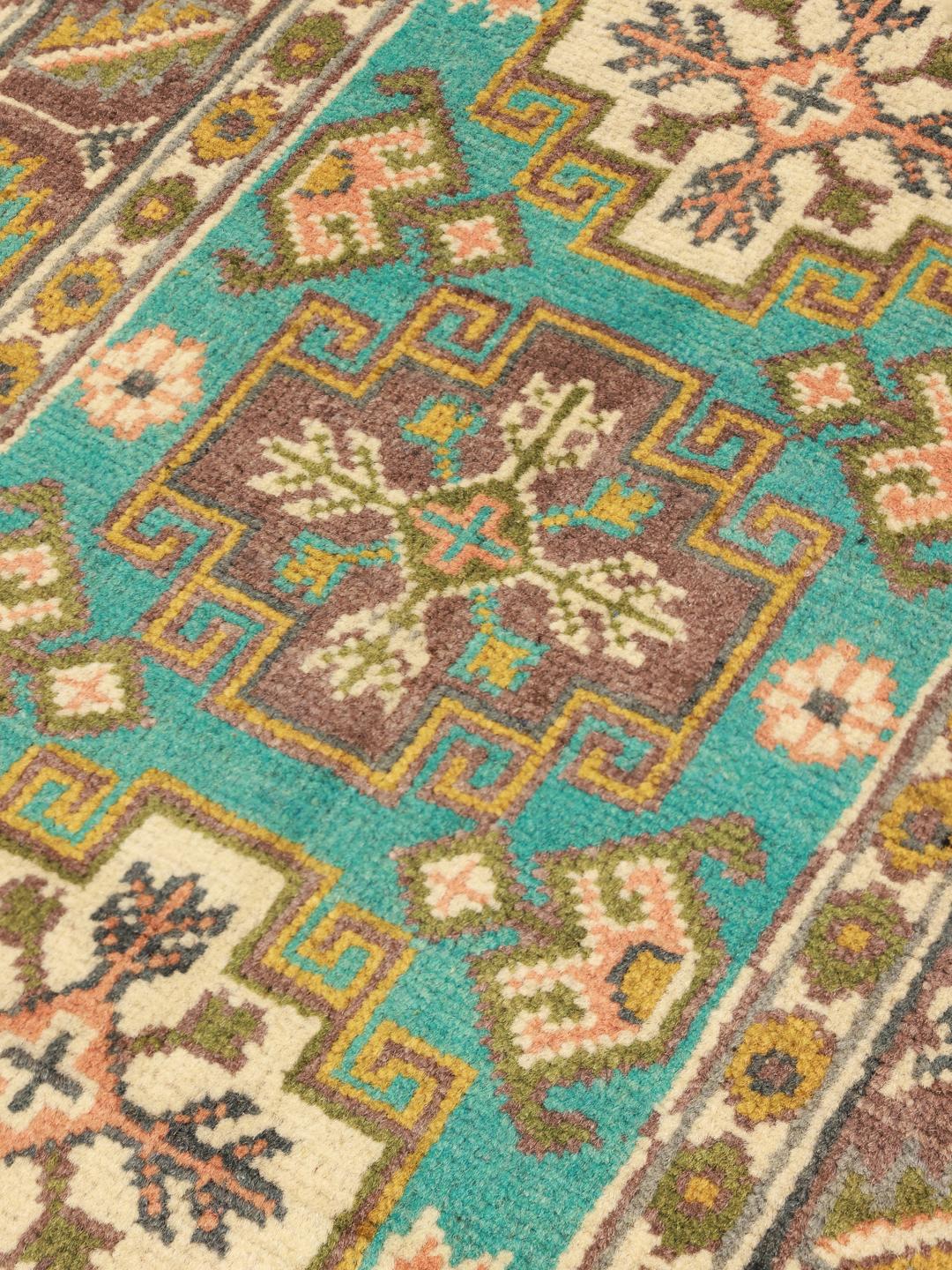 Handgeknoopt Afghaans Kazak-tapijt met blauwe, bruine en okerkleurige geometrische patronen.