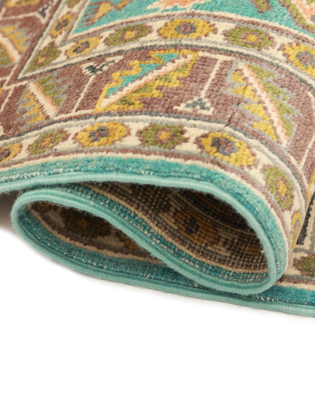 Handgeknoopt Afghaans Kazak-tapijt met blauwe, bruine en okerkleurige geometrische patronen.