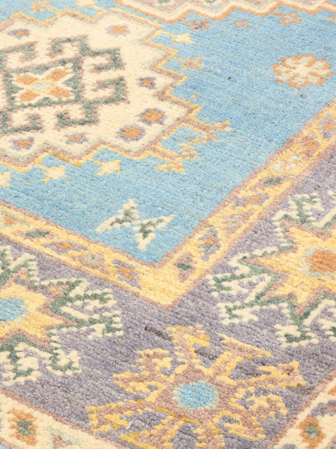 Handgeknoopt Afghaans Kazak-tapijt met blauwe achtergrond en geometrische motieven.