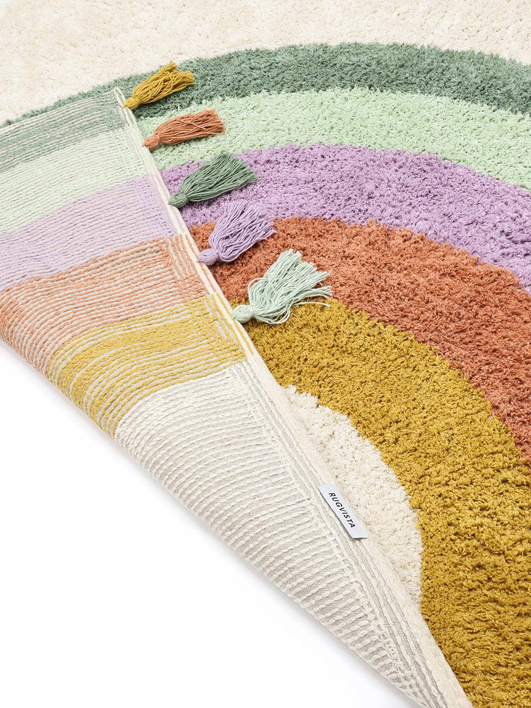 Een rechthoekig, veelkleurig tapijt met een speels regenboogpatroon en kwastjes.