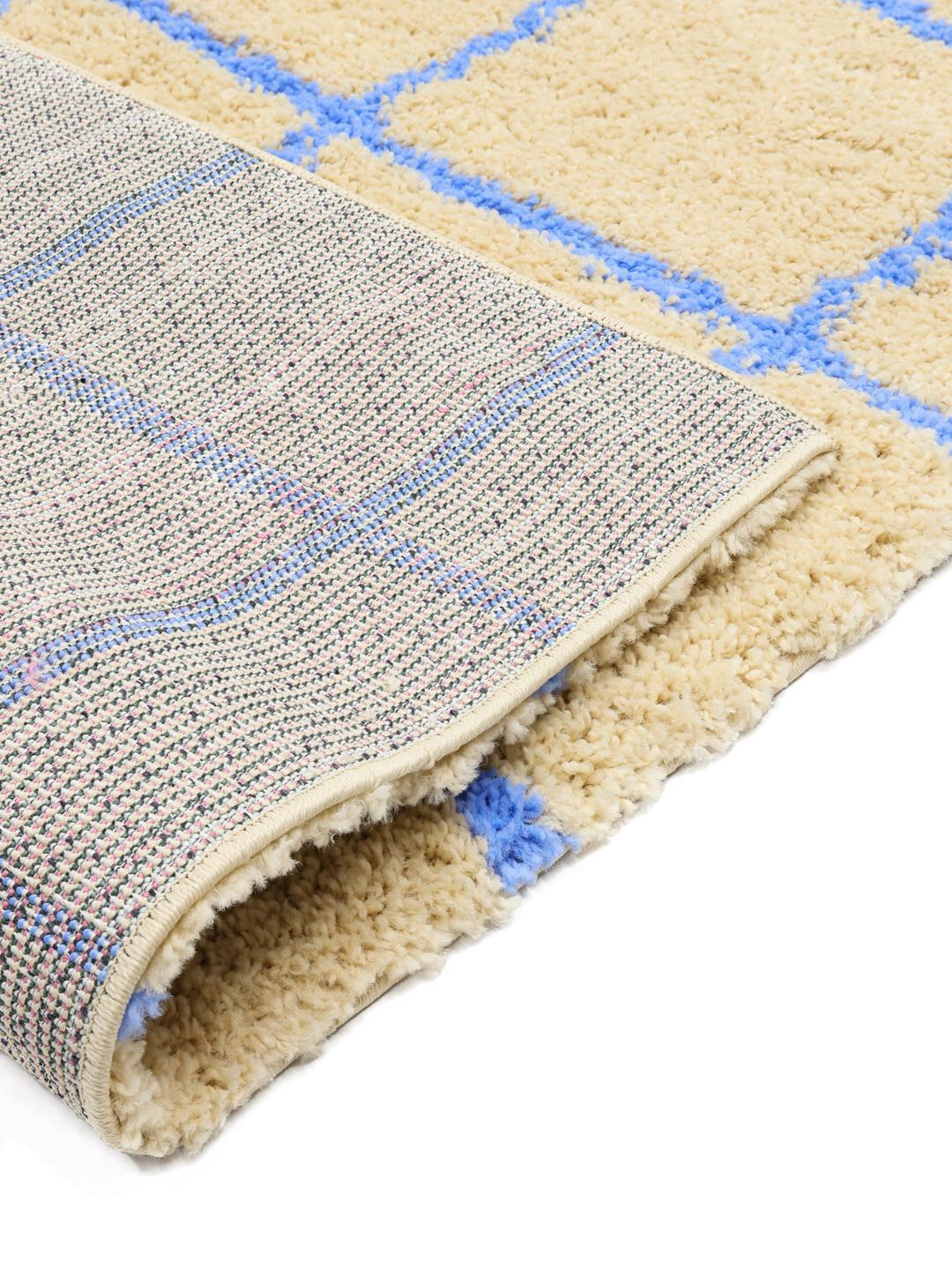 Tapis beige et bleu avec un motif à grille