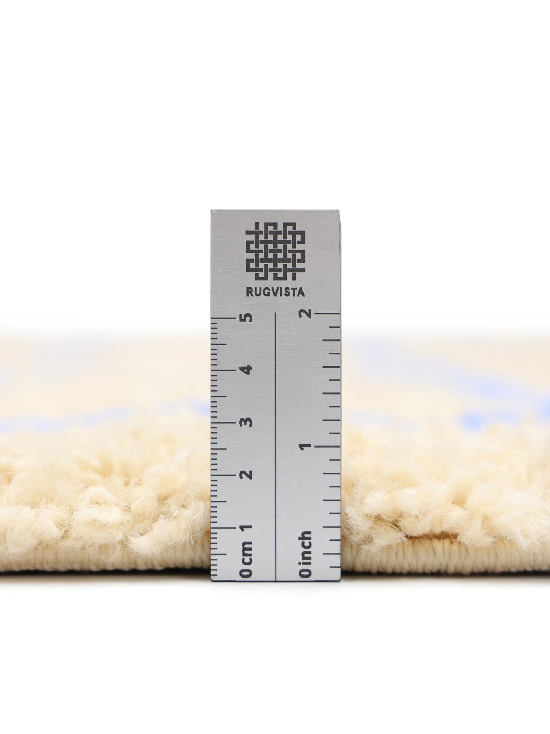 Rundt tæppe i beige og blå med mønster