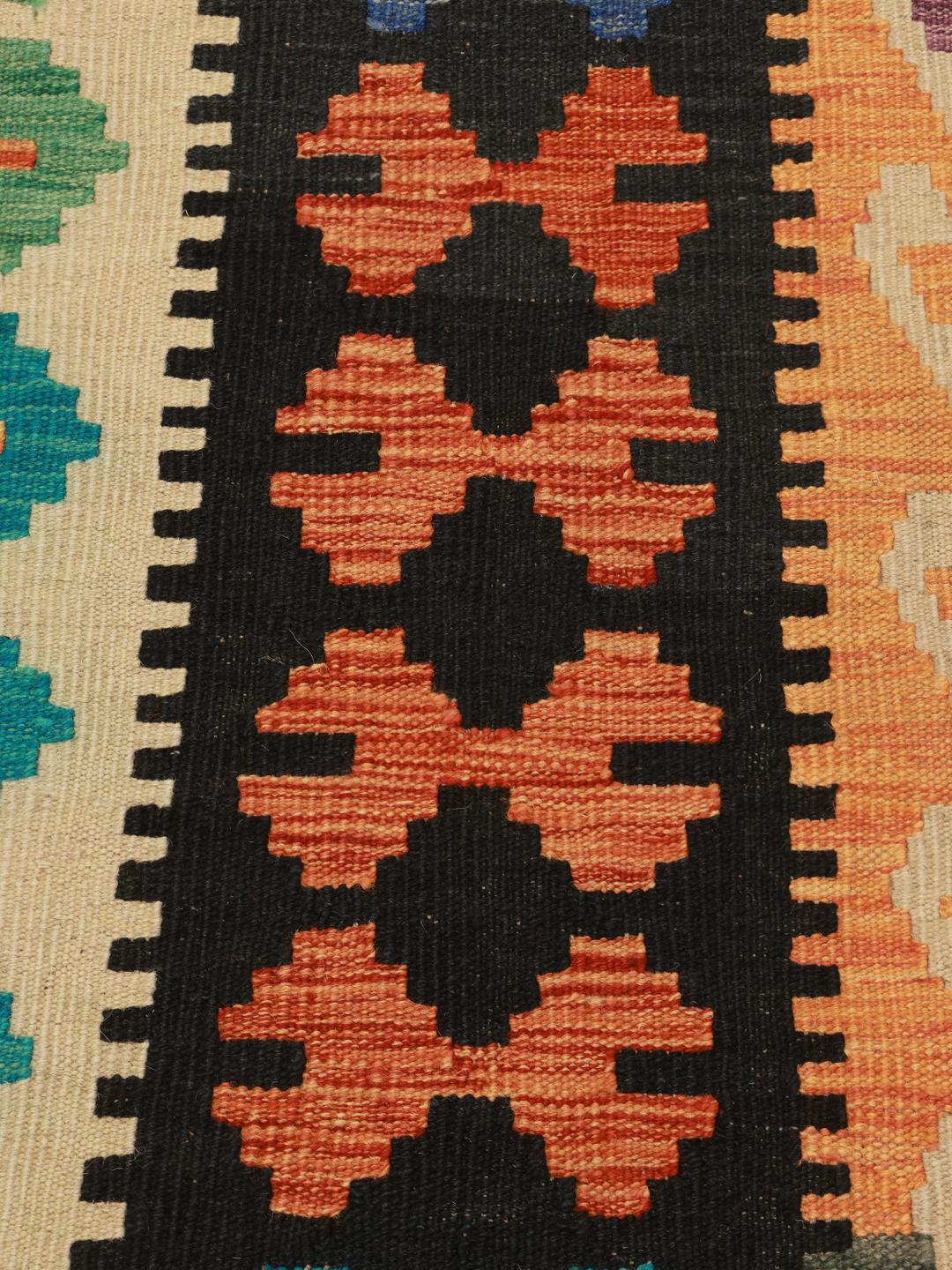 A large rectangular hand-woven Afghan Kelim rug featuring a vibrant multicolor geometric diamond pattern.