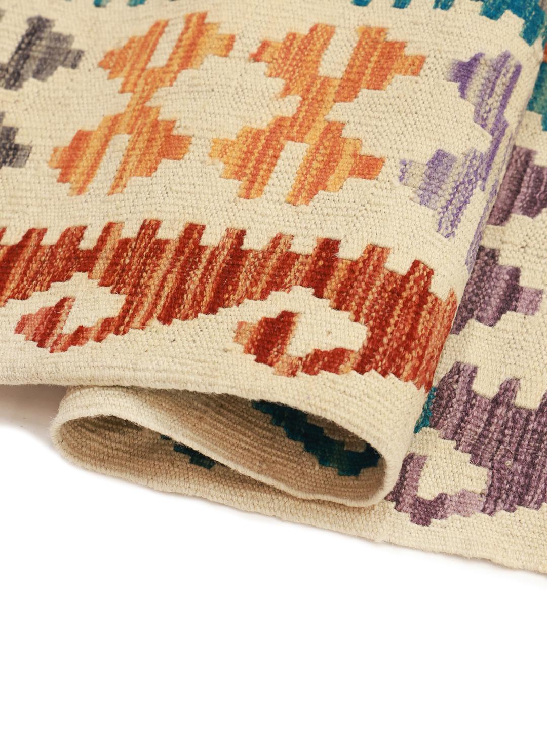 A large, rectangular Afghan Kelim rug featuring a vibrant geometric pattern in multicolor Wool.