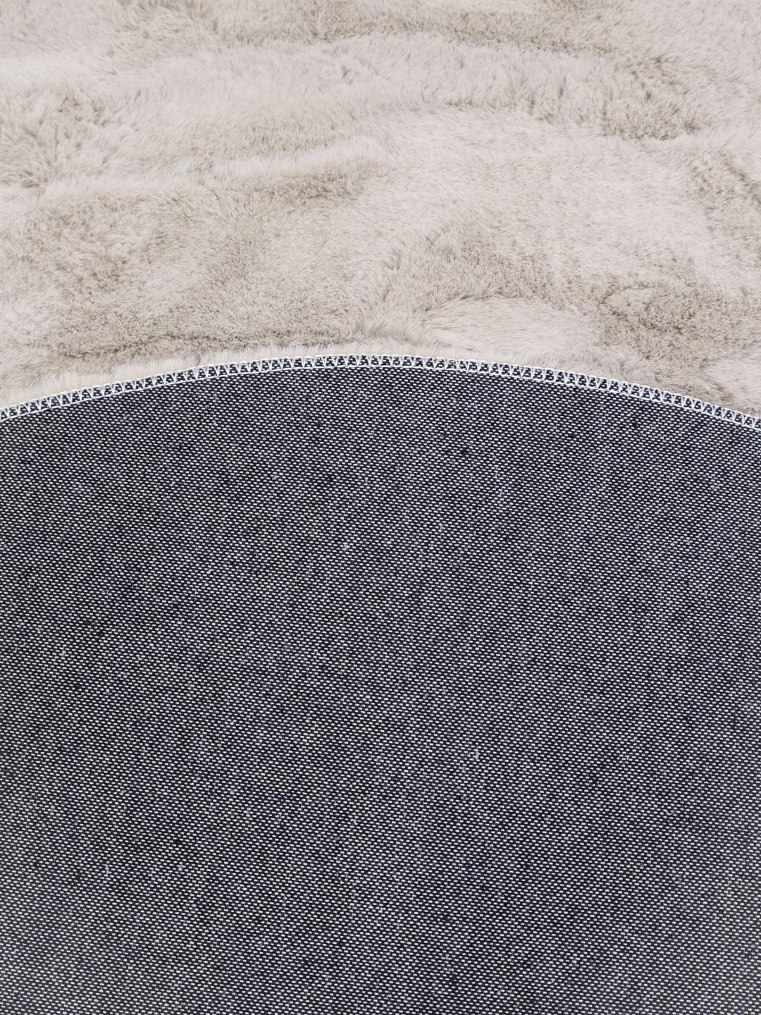 Rundt beige tæppe med en blød plystekstur