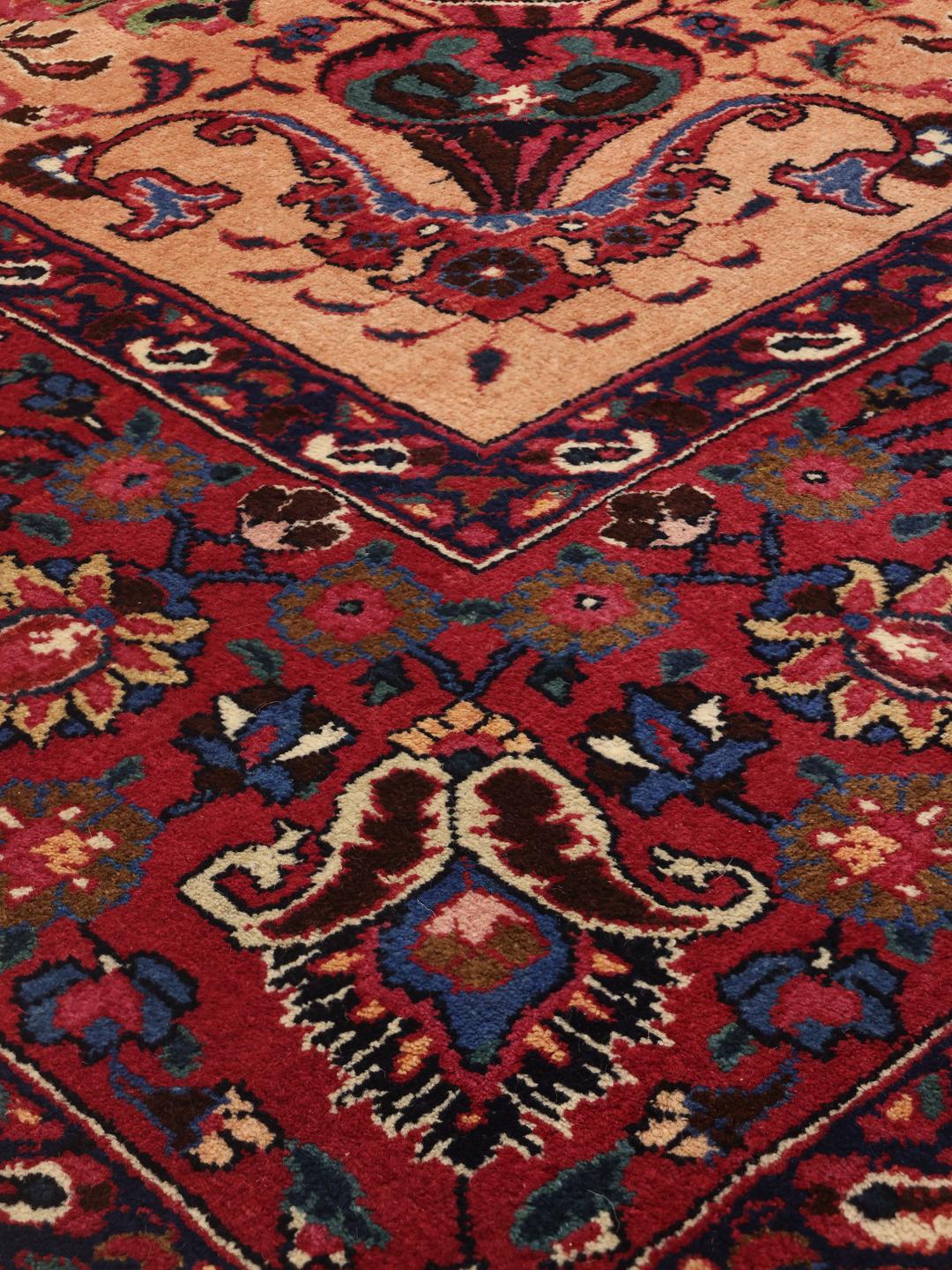 Een groot handgeknoopt Mashad-tapijt uit het Midden-Oosten met een beige veld en bloemmotieven.