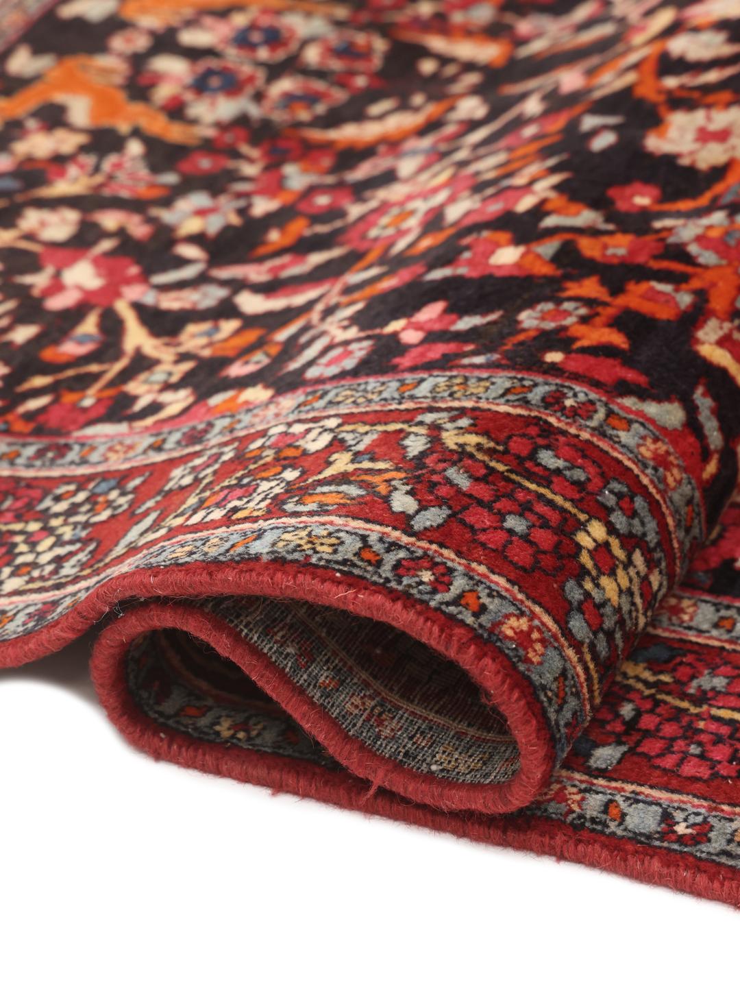 A hand-knotted Hamadan rug from the Middle East with a dark-red and black floral design.