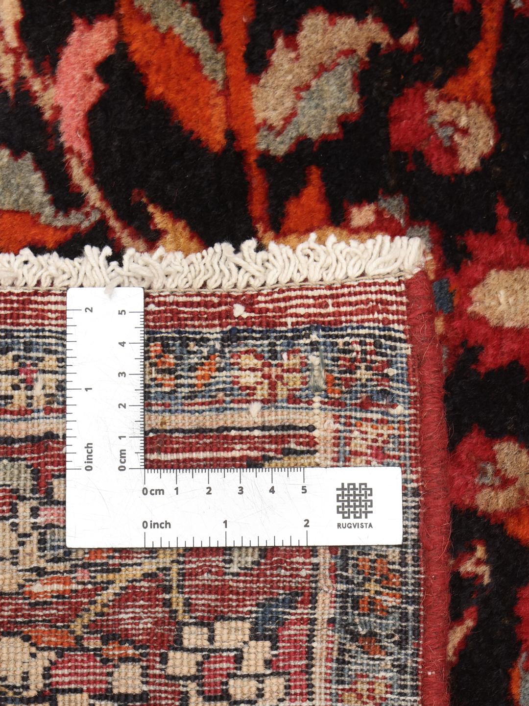 A hand-knotted Hamadan rug from the Middle East with a dark-red and black floral design.