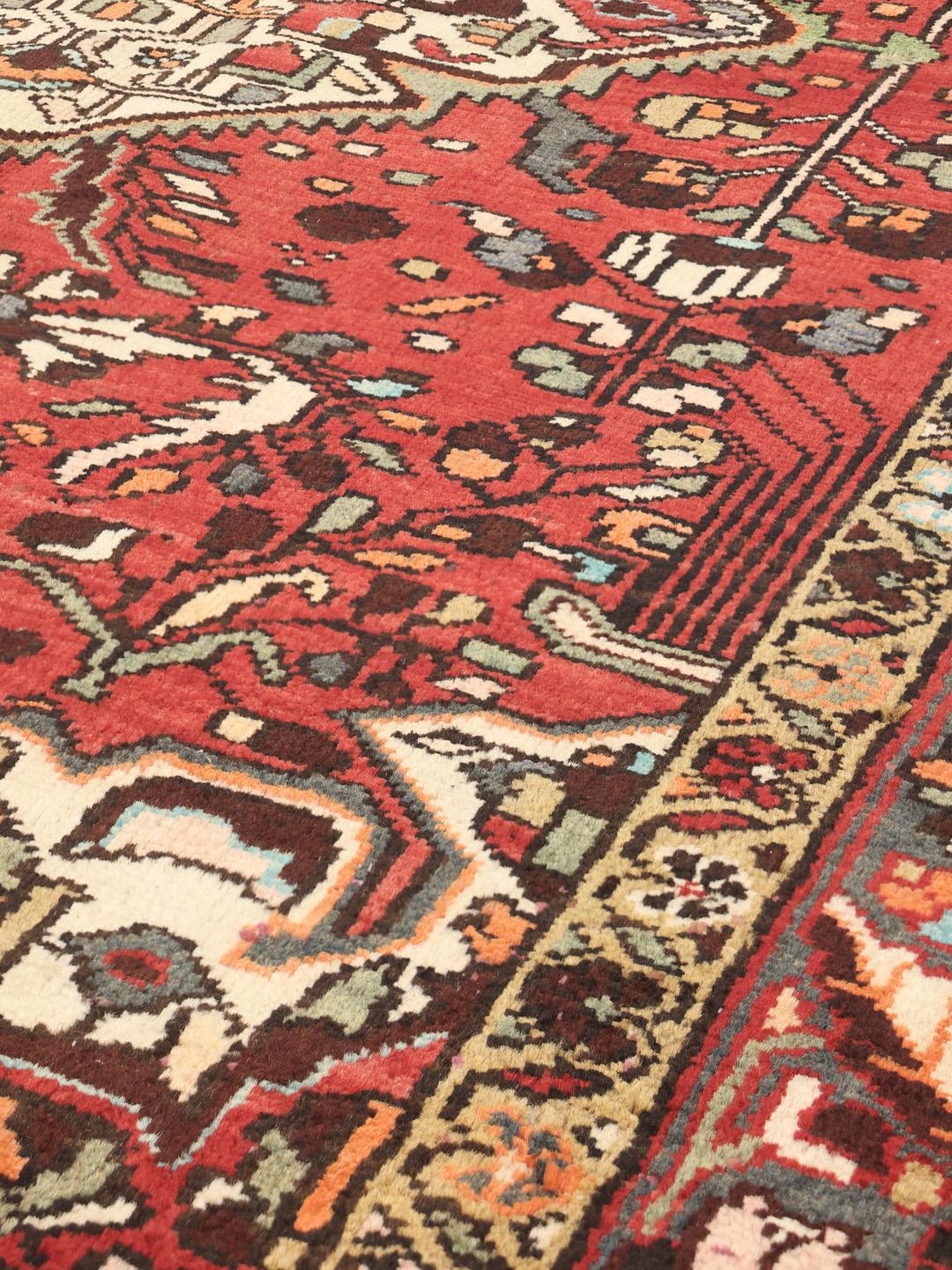 A hand-knotted Hamadan rug from the Middle East with a red field and medallion pattern.