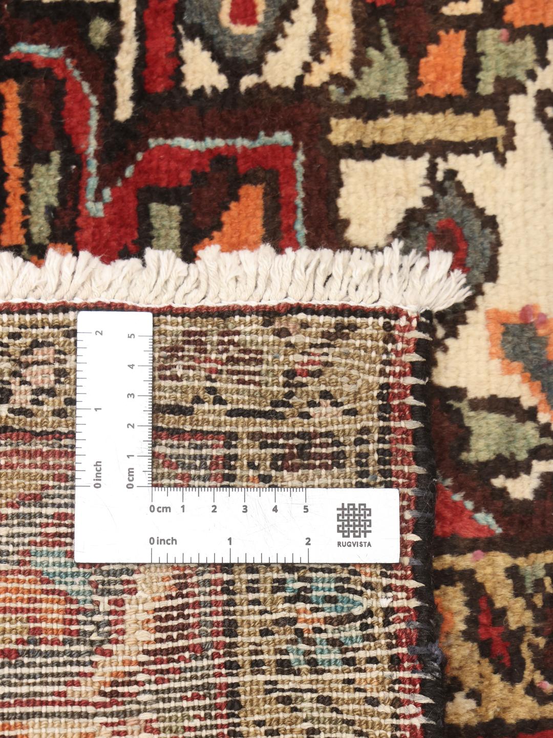 A hand-knotted Hamadan rug from the Middle East with a red field and medallion pattern.