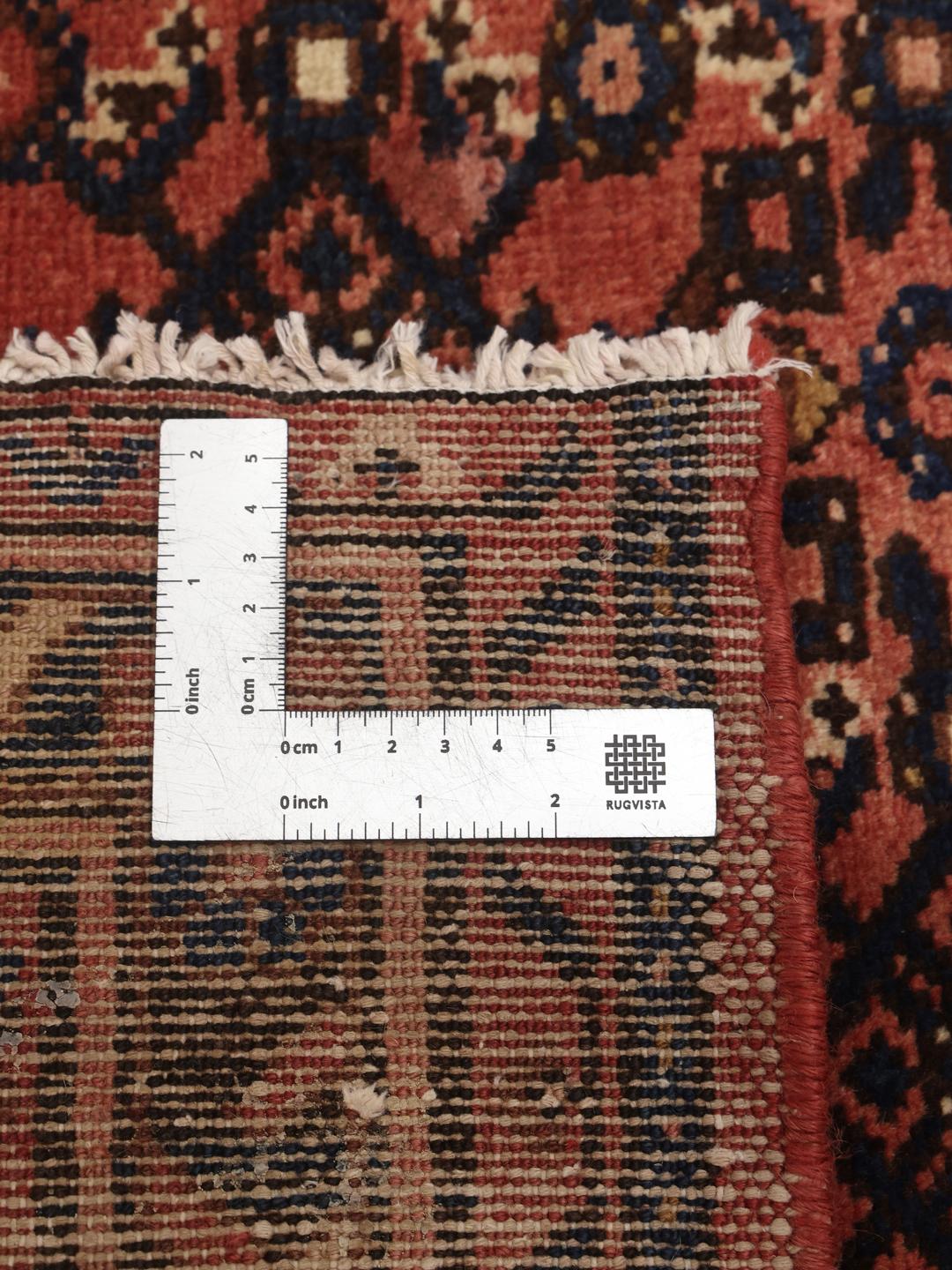 A hand-knotted Hosseinabad runner from the Middle East featuring a red and dark blue geometric pattern.