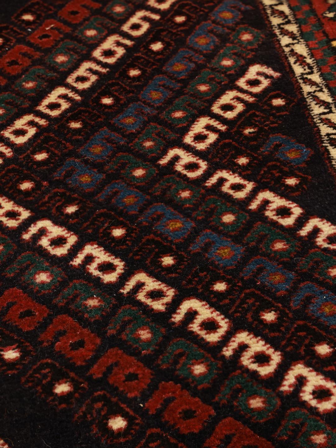 Hand-knotted Afshar Shahre Babak rug with dark-red and black geometric motifs.