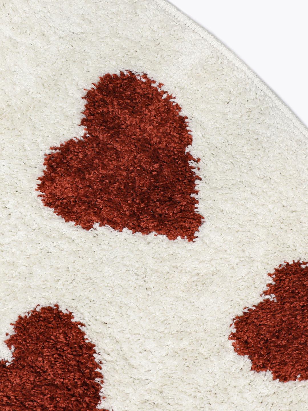 Tapis rond avec un motif de cœurs rouges sur fond blanc cassé