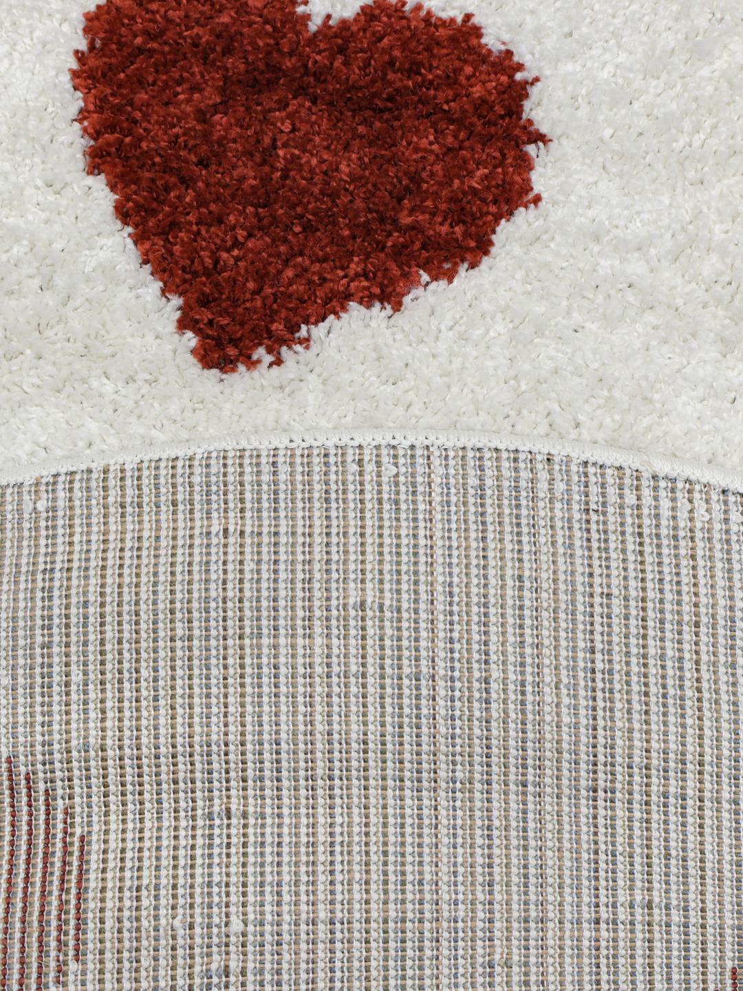 Tapis rond avec un motif de cœurs rouges sur fond blanc cassé