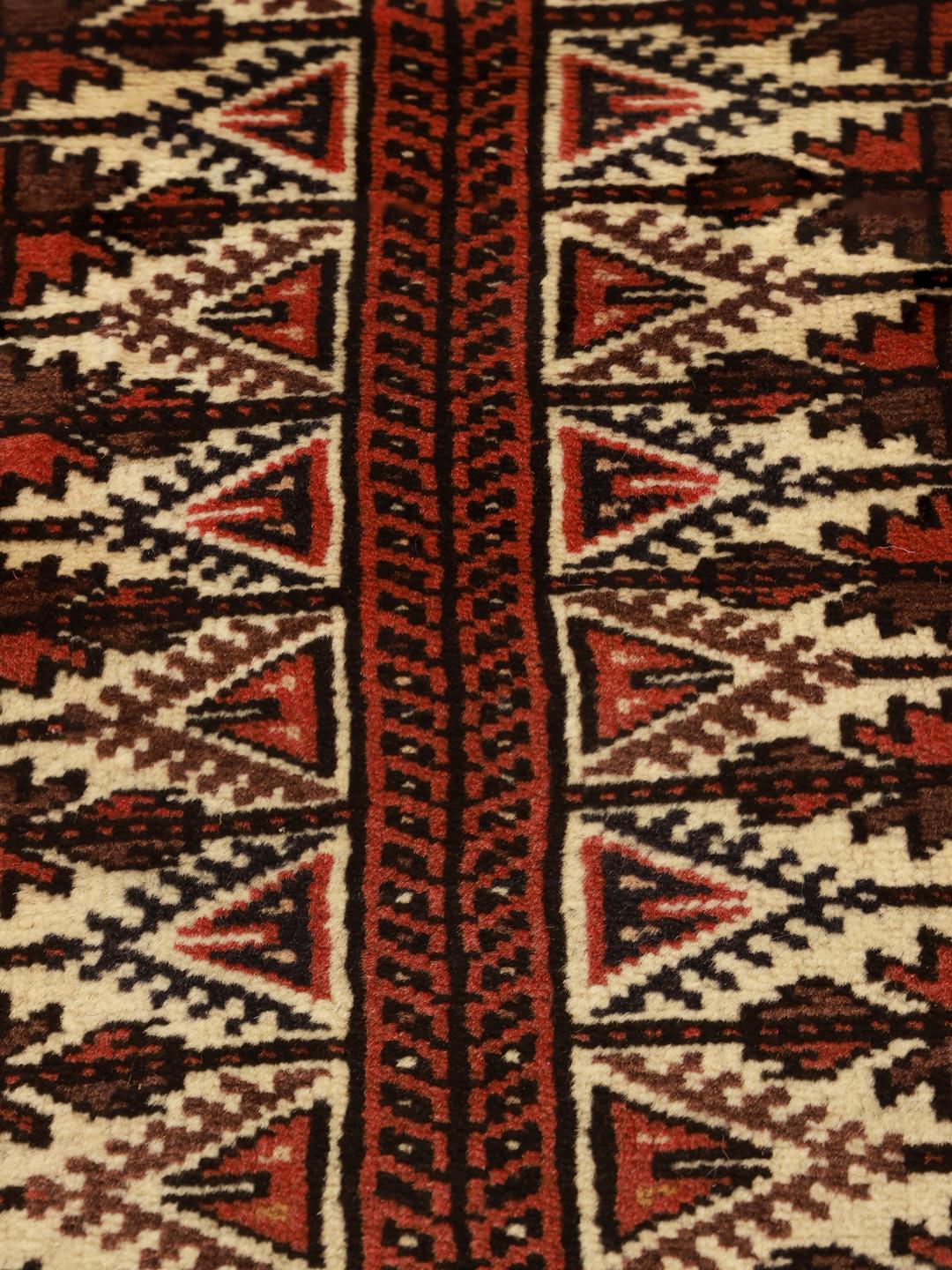 Handgeknoopt Baluch-tapijt uit het Midden-Oosten in rode en beige tinten.