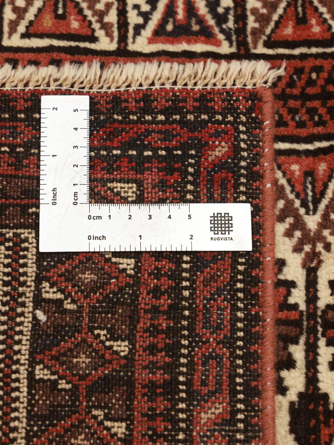 Handgeknoopt Baluch-tapijt uit het Midden-Oosten in rode en beige tinten.
