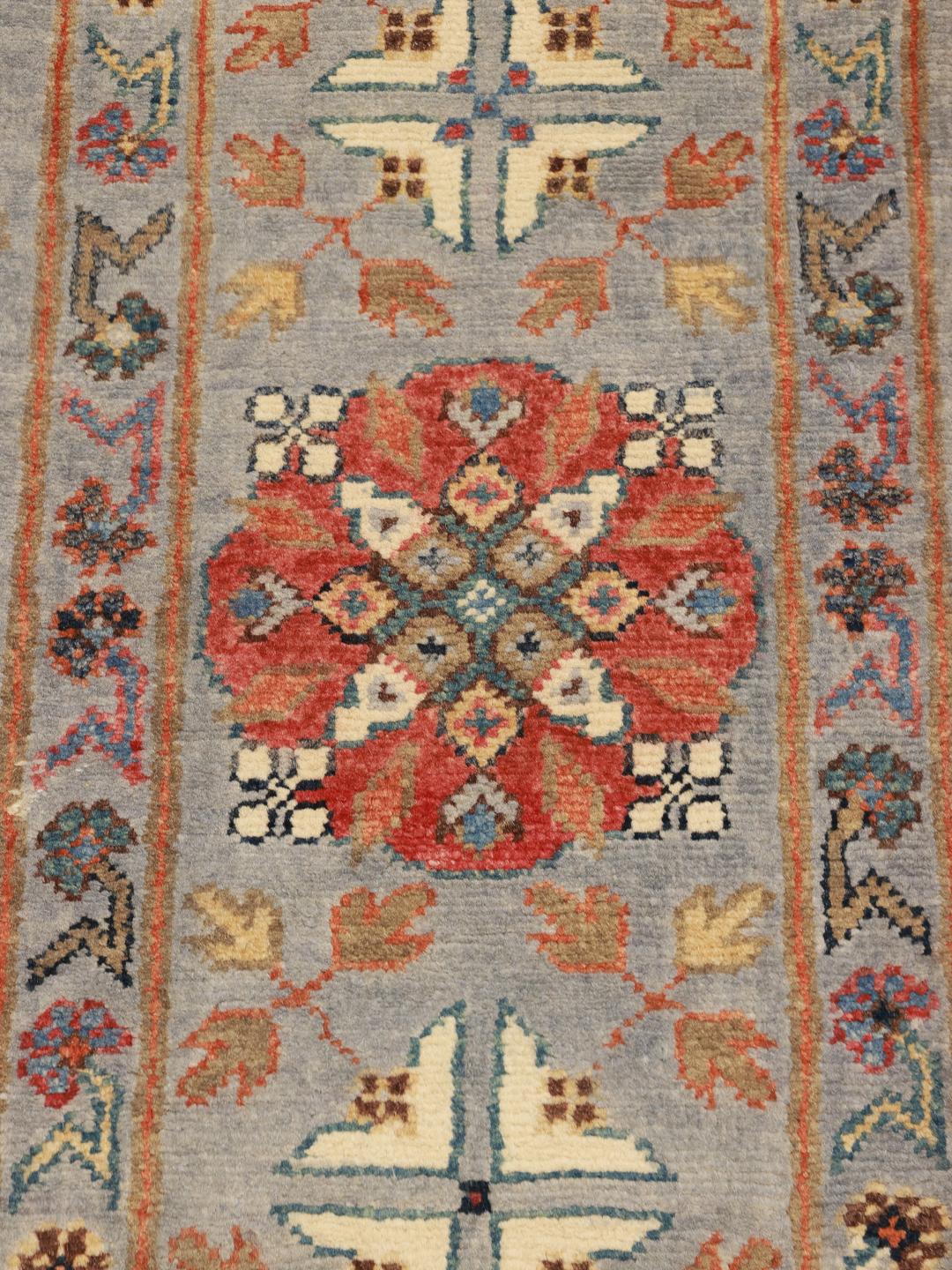 Tapis afghan noué à la main avec un champ bleu clair et des bordures décoratives