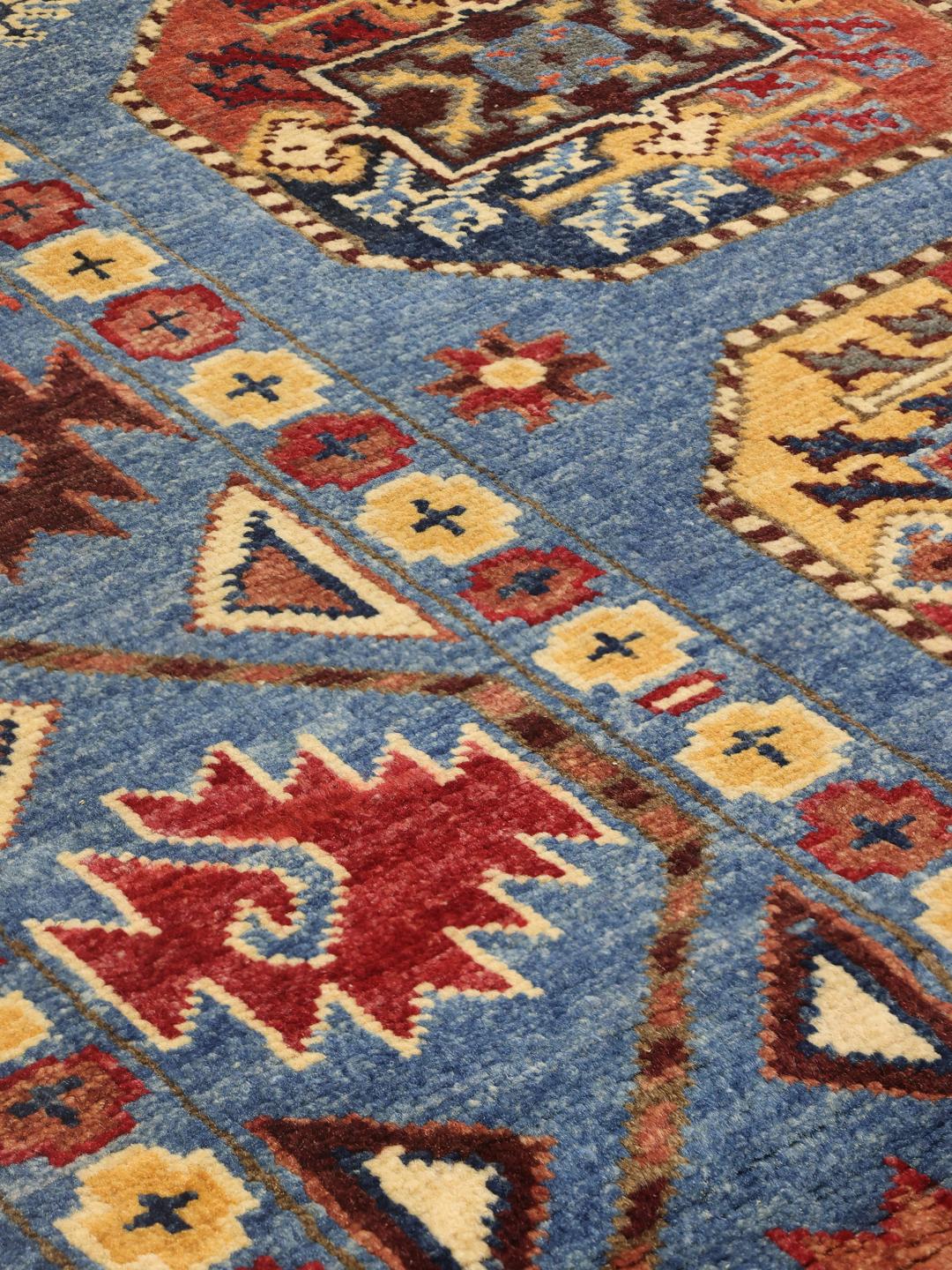 Handgeknoopt Kazak-tapijt uit Afghanistan met een blauwe achtergrond en geometrische medaillonpatronen.