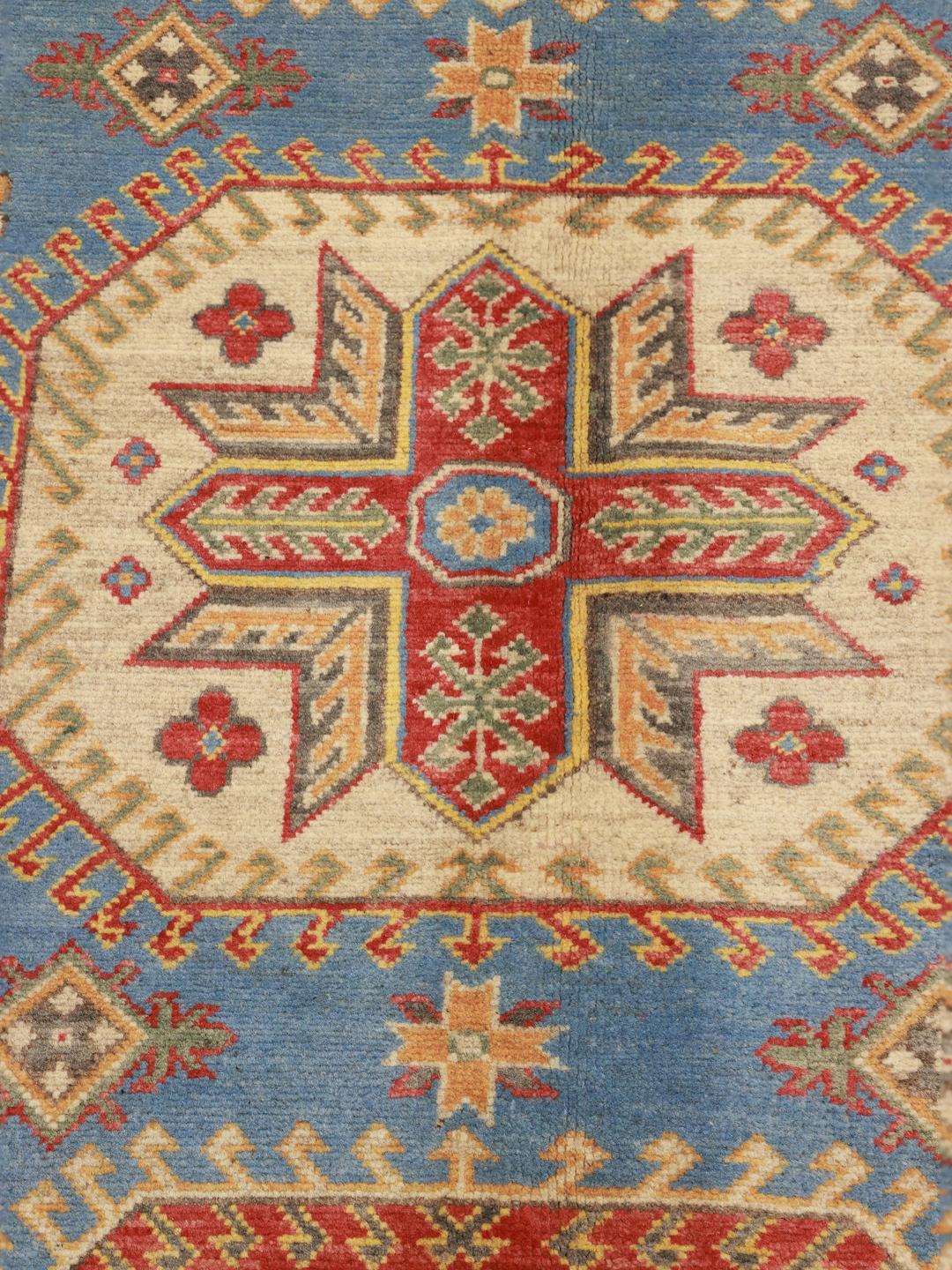 Hand-knotted Kazak rug from Afghanistan with a blue field and geometric patterns.