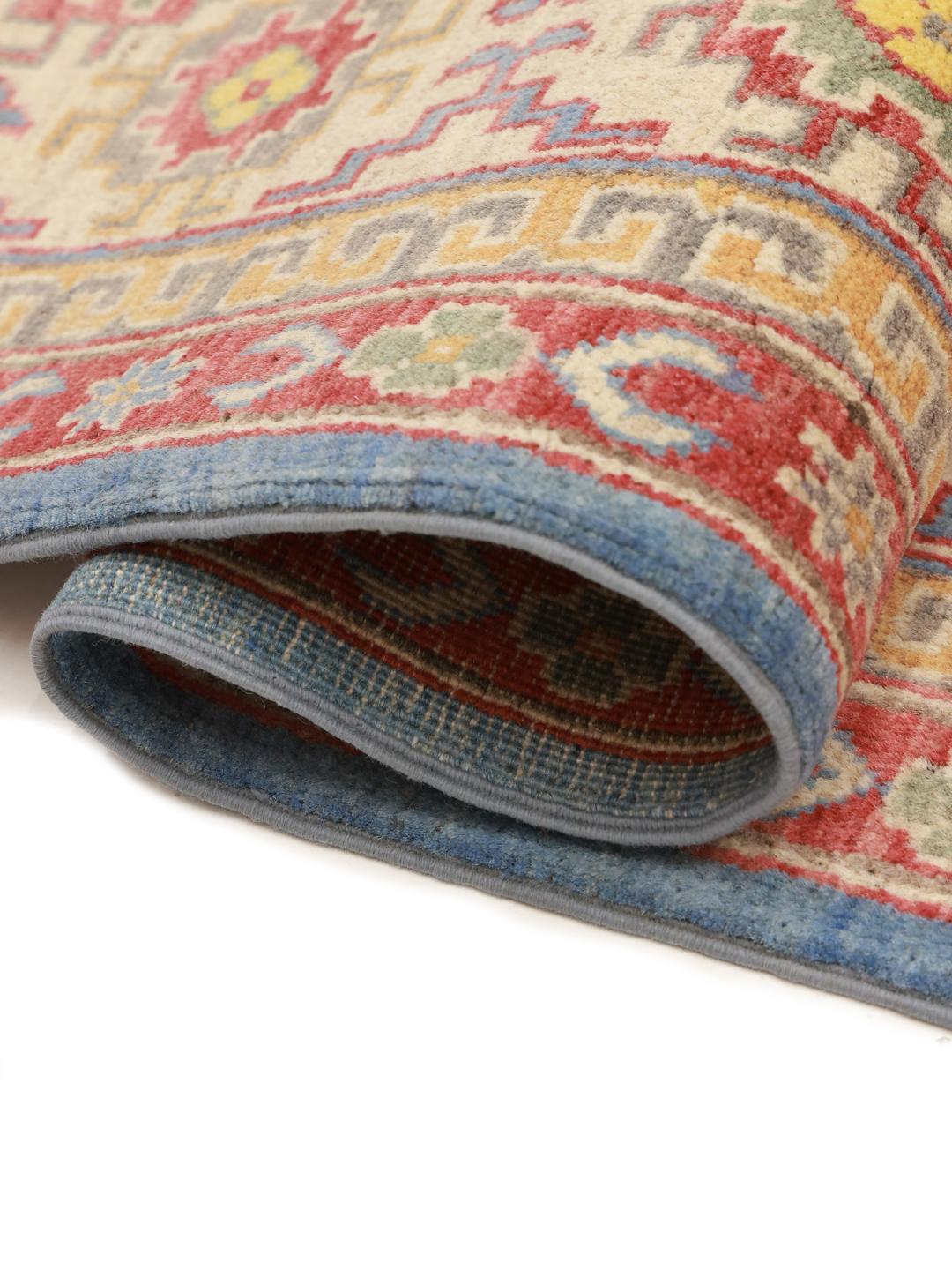 Hand-knotted Kazak rug from Afghanistan with a blue field and geometric patterns.