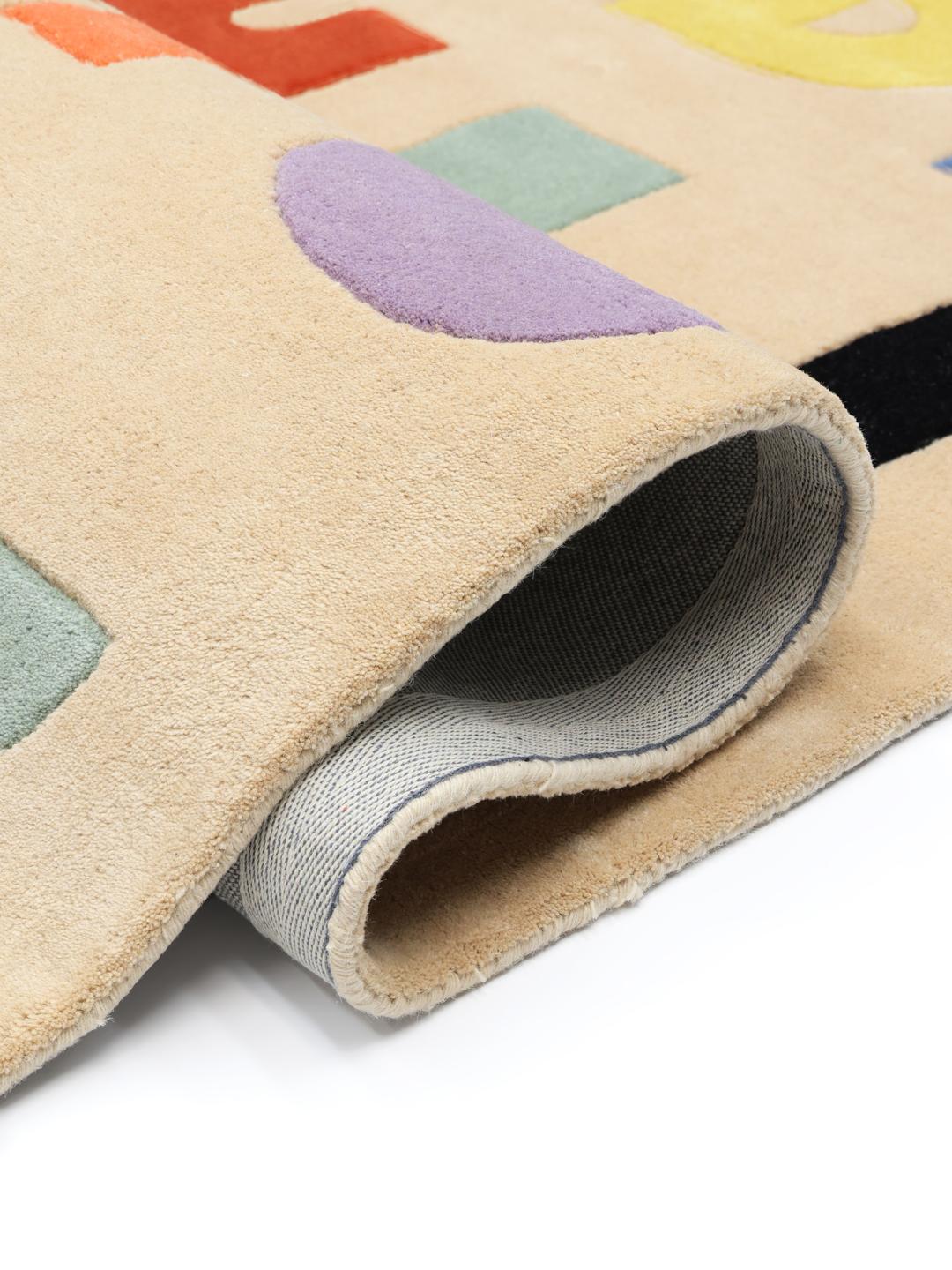 Een beige vloerkleed met een kleurrijk alfabetpatroon in verschillende tinten