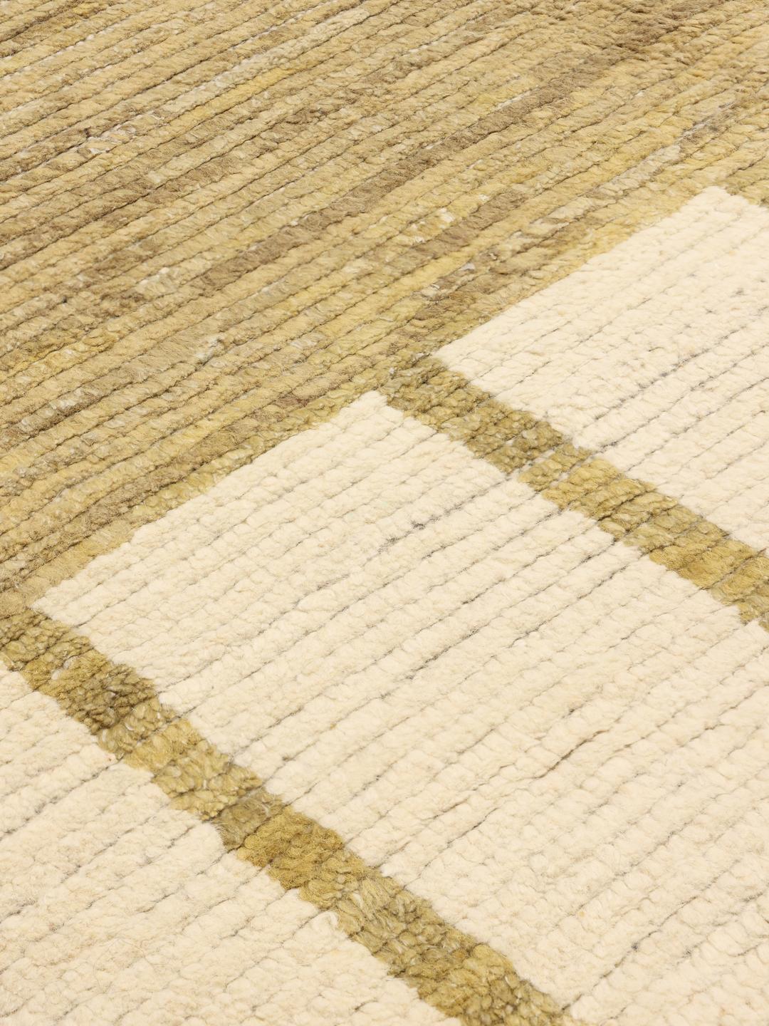 A large rectangular hand-knotted rug from Afghanistan in beige and gold with geometric lines and block motifs.