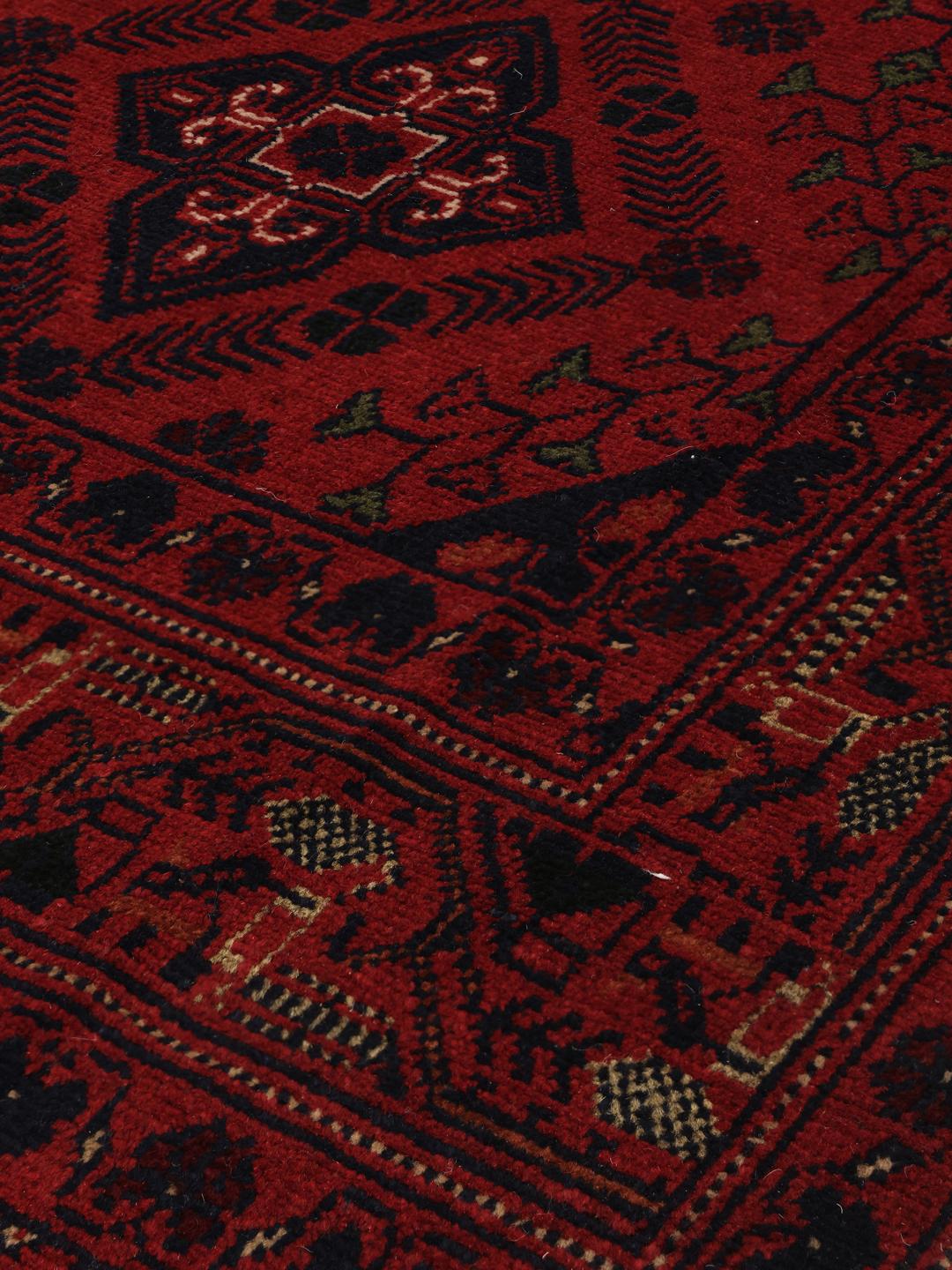 Tapis Afghan Khal Mohammadi noué à la main en rouge profond avec des motifs de médaillons géométriques.