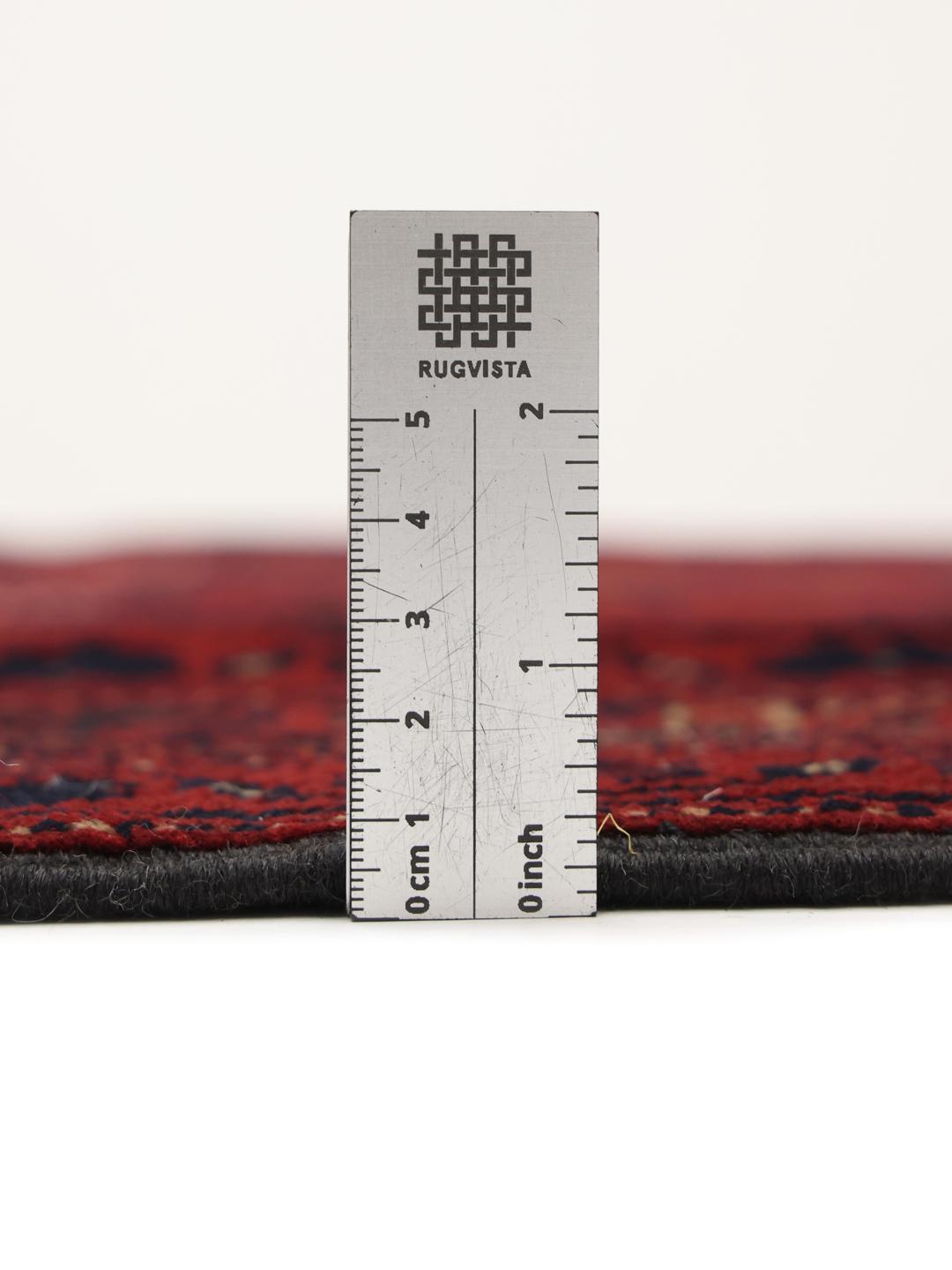 Tapis Afghan Khal Mohammadi noué à la main en rouge profond avec des motifs de médaillons géométriques.