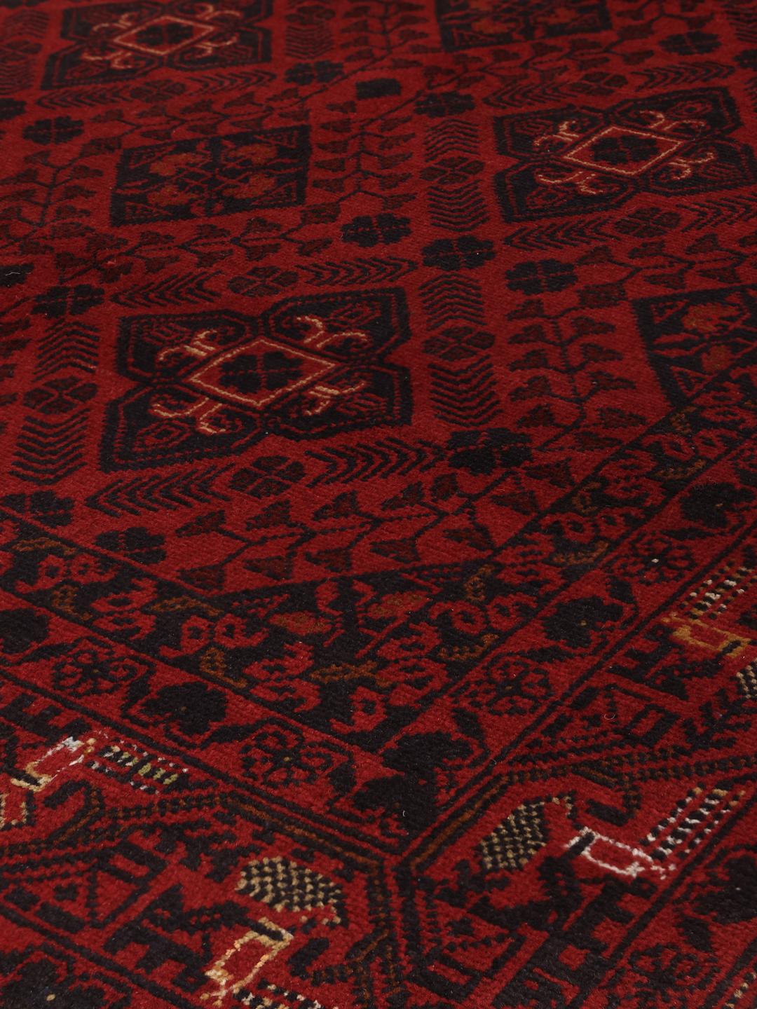 Un tapis Afghan Khal Mohammadi noué à la main présentant un champ rouge profond avec des motifs de médaillons géométriques.