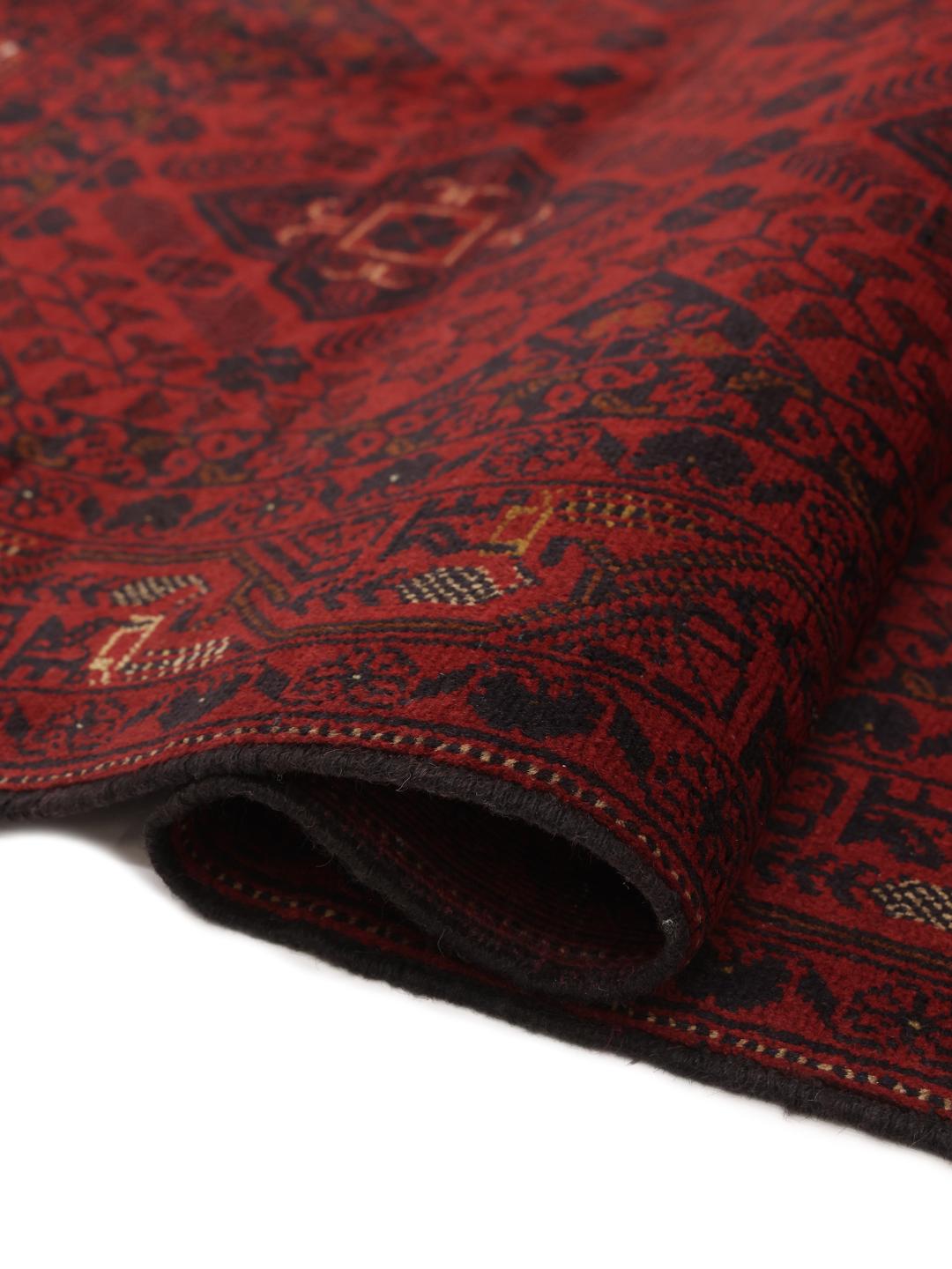 Un tapis Afghan Khal Mohammadi noué à la main présentant un champ rouge profond avec des motifs de médaillons géométriques.