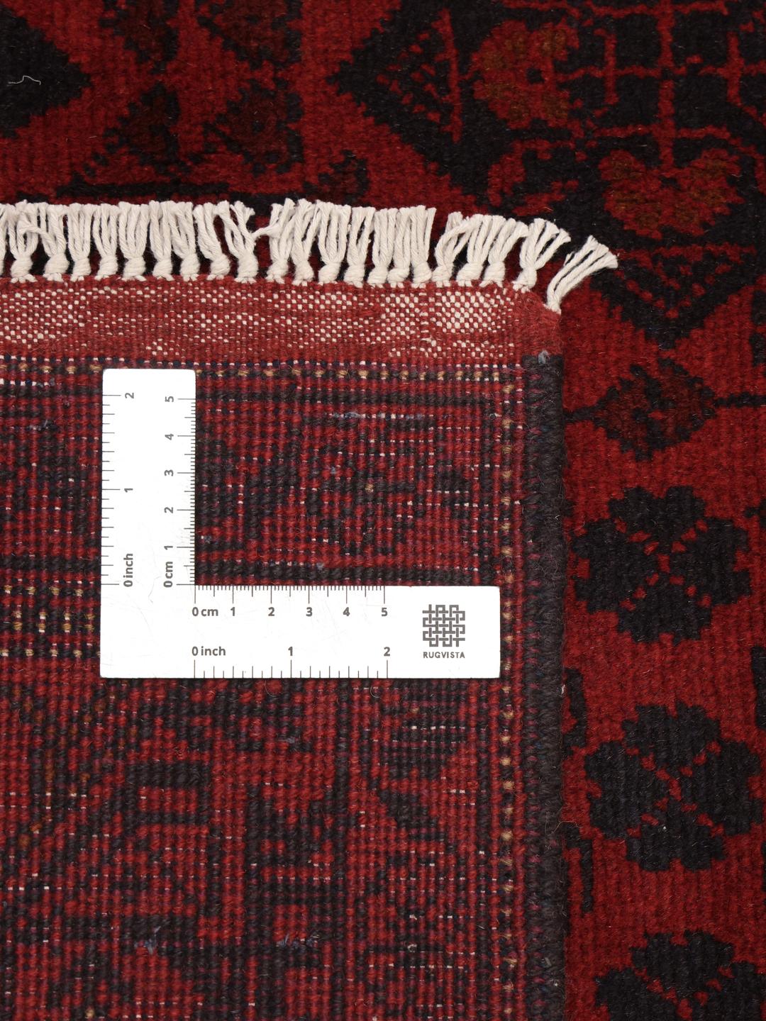 Un tapis Afghan Khal Mohammadi noué à la main présentant un champ rouge profond avec des motifs de médaillons géométriques.