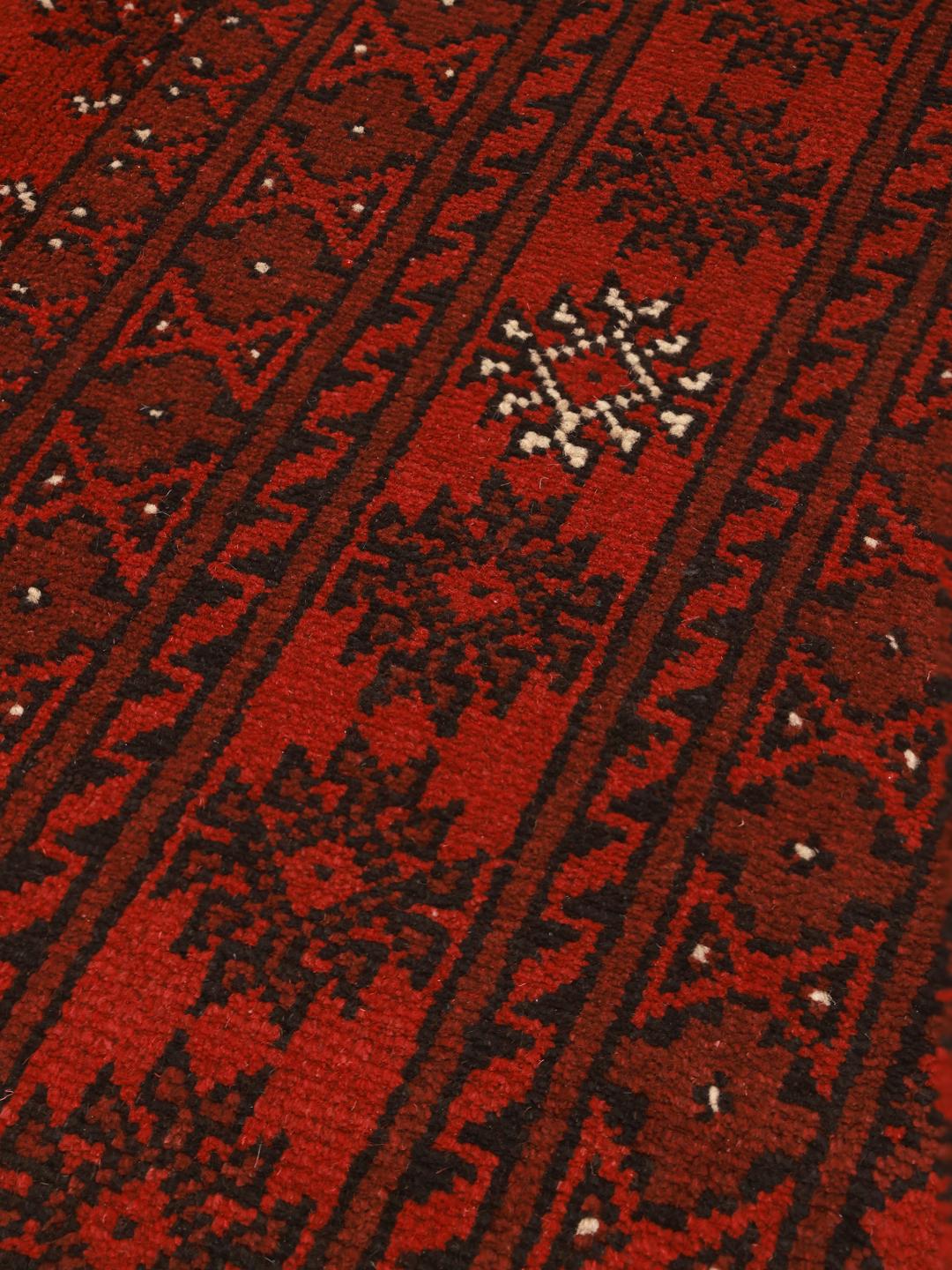 Håndknyttet Afghan Akhche-tæppe i mørkerød med traditionelle geometriske motiver.