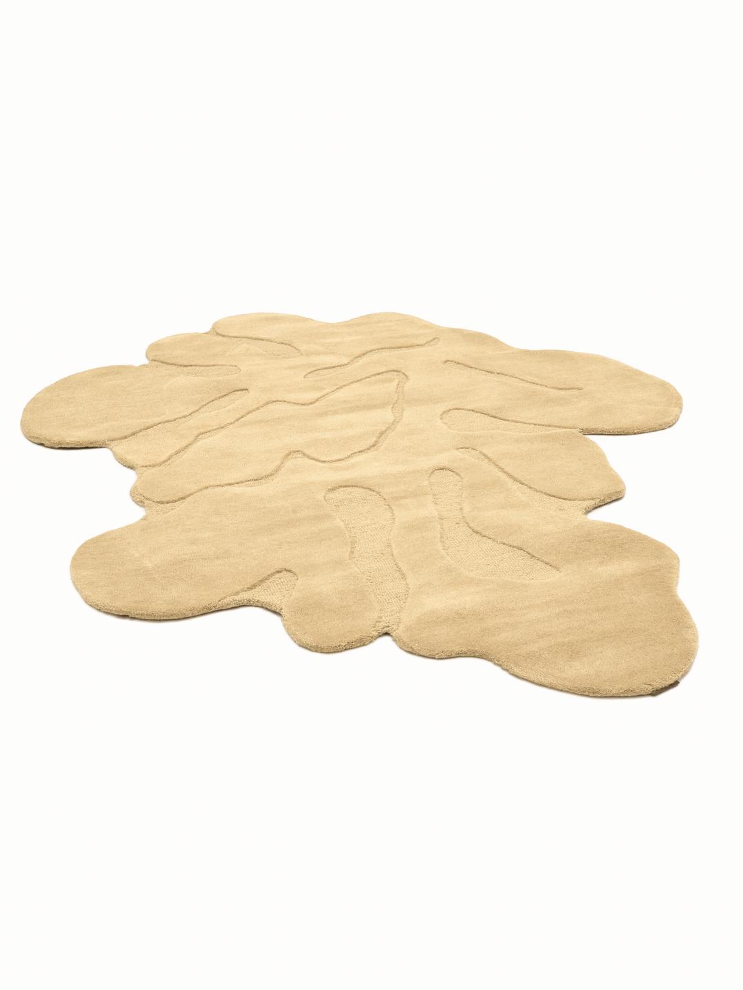Uregelmæssigt formet beige tæppe