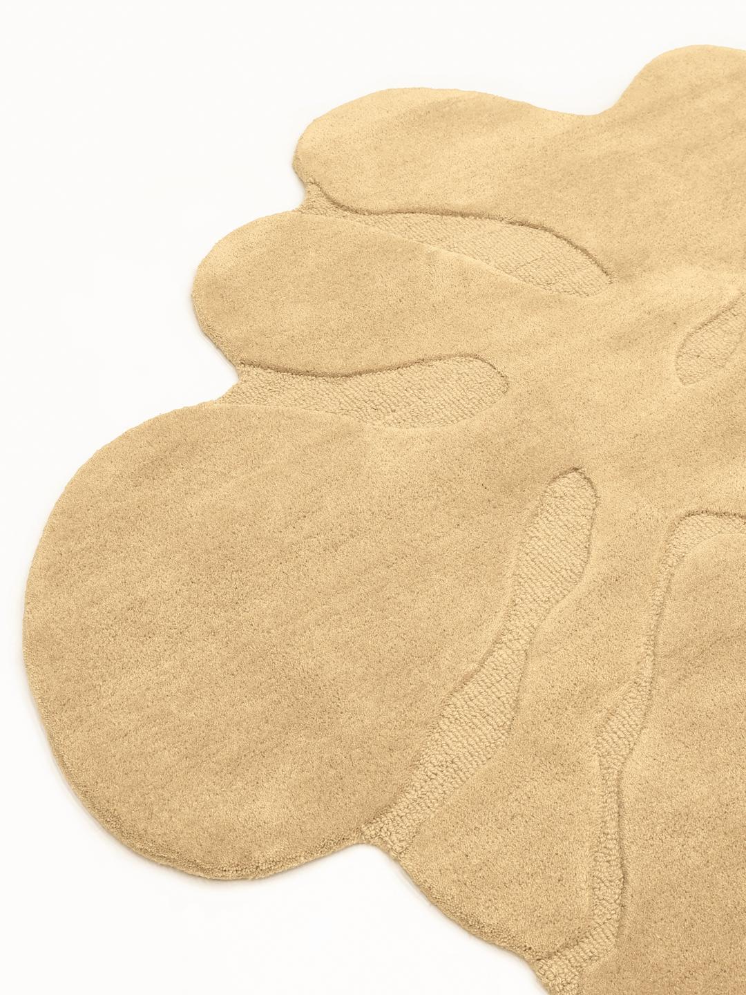 Uregelmæssigt formet beige tæppe