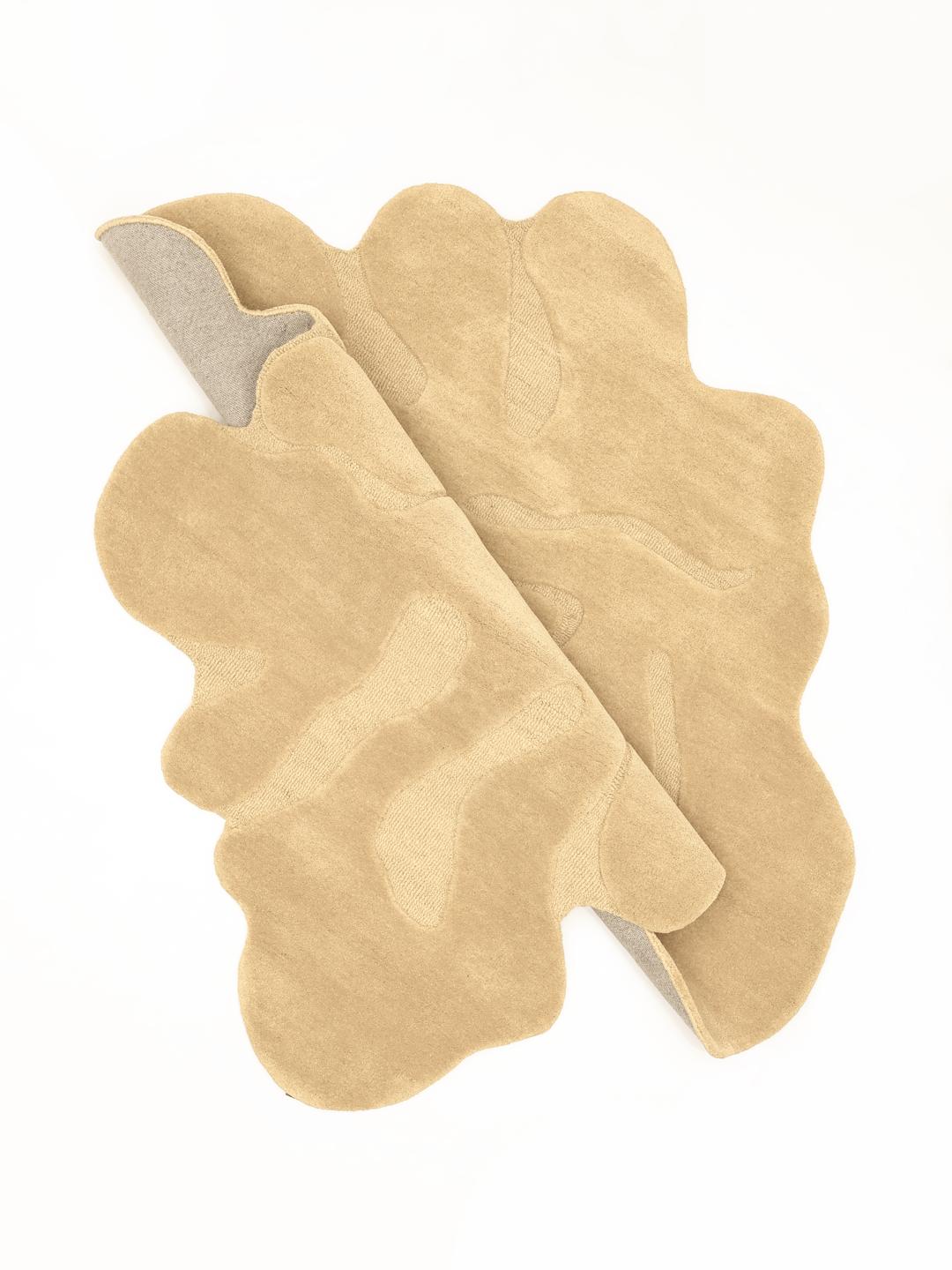 Uregelmæssigt formet beige tæppe