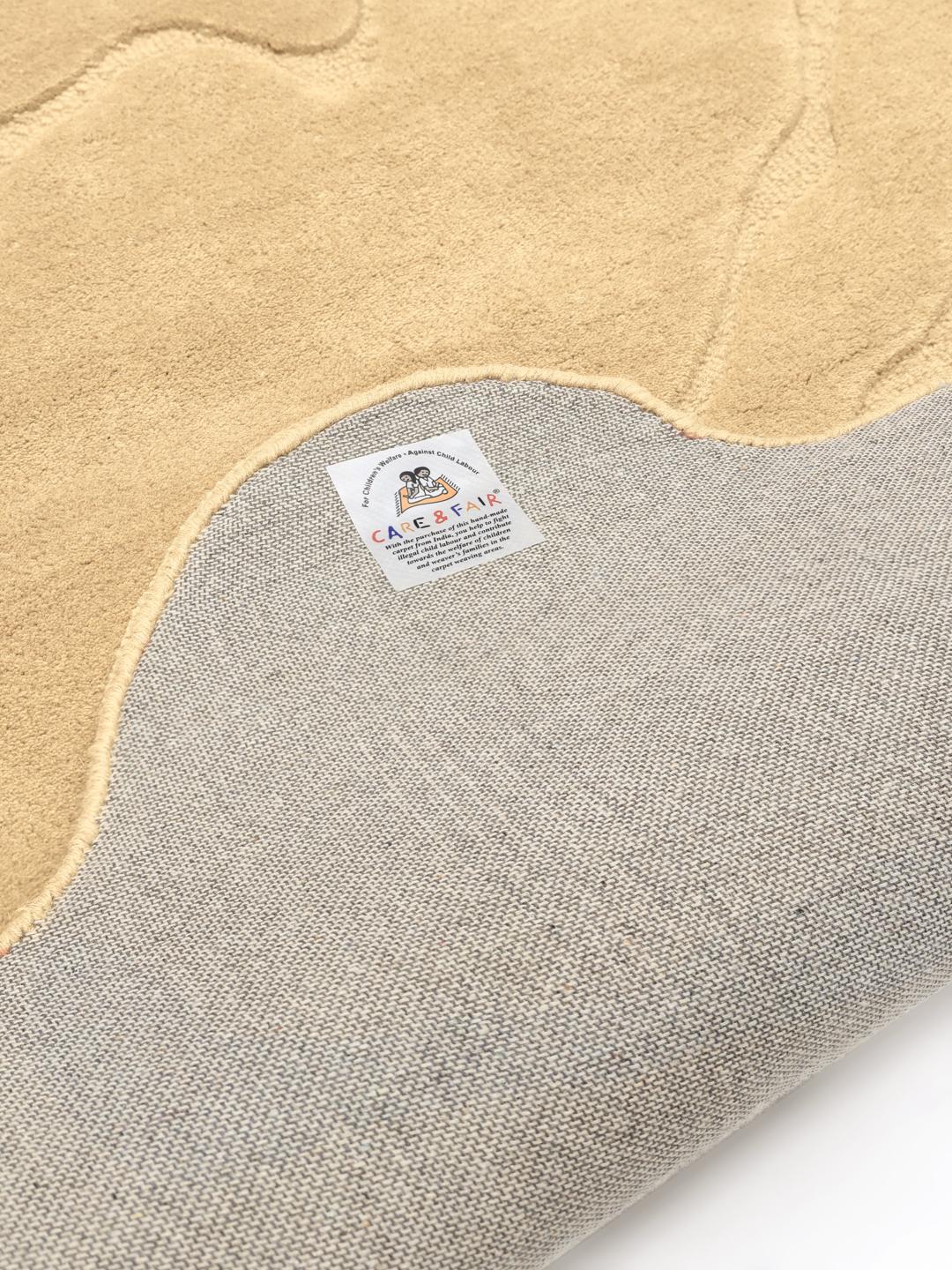 Uregelmæssigt formet beige tæppe