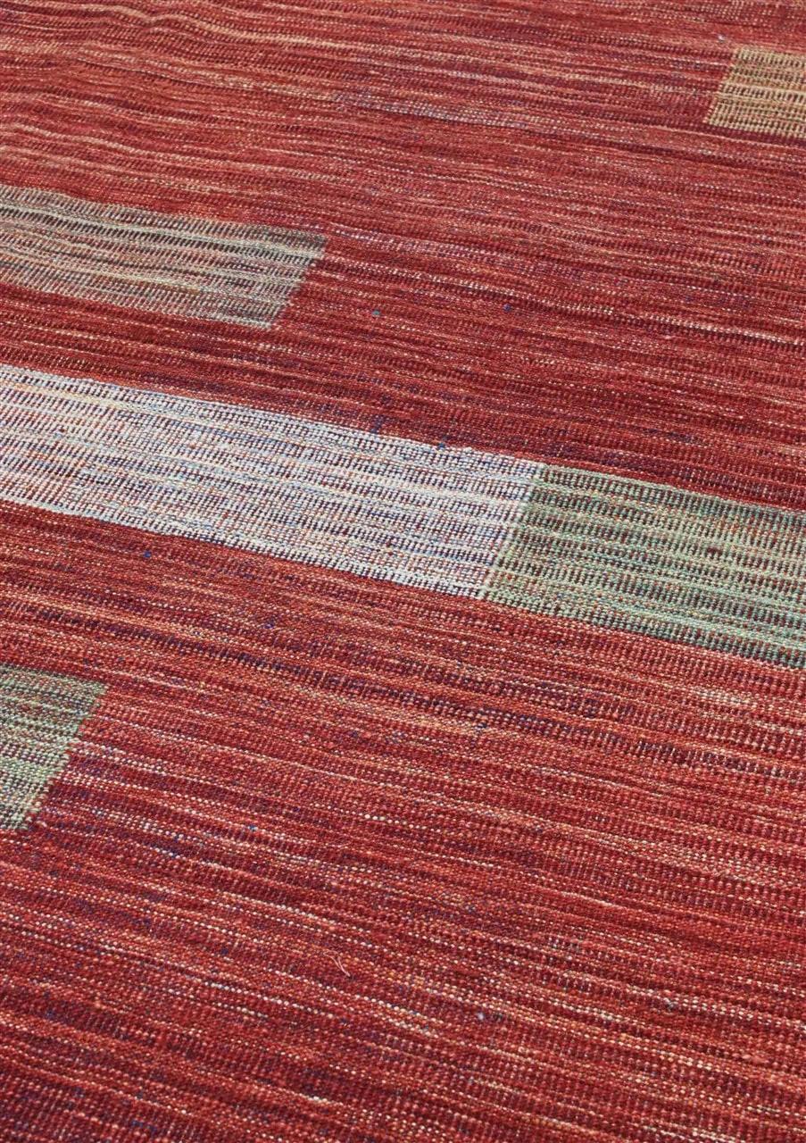 Een rood Afghaans kelim vloerkleed met moderne lineaire patronen