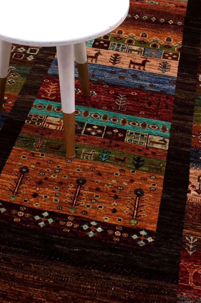 Un long tapis couloir afghan présentant un motif géométrique et tribal multicolore et vibrant.