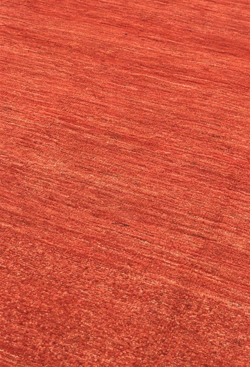 Een handgeknoopt Gabbeh Modern-tapijt uit Afghanistan in een rijke rode tint.