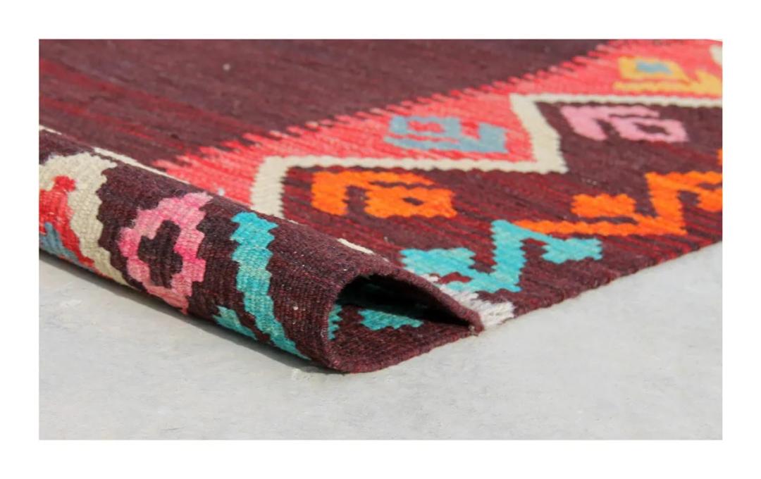 Tapis Kelim afghan tissé à la main avec un champ sombre et une bordure géométrique colorée