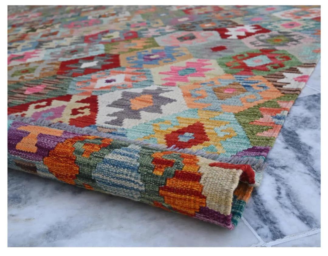 Un grand tapis rectangulaire Kelim Afghan présentant un motif de losanges multicolores avec des dessins géométriques traditionnels