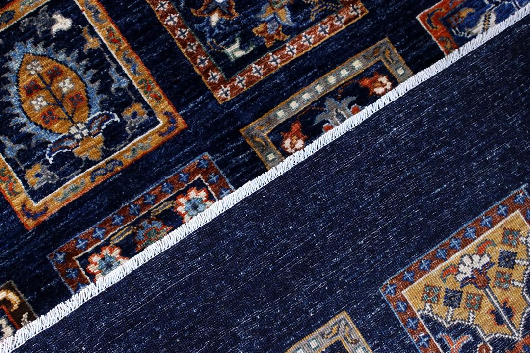Håndknyttet afghansk tæppe med et gitter af dekorative motiver på en mørkeblå baggrund