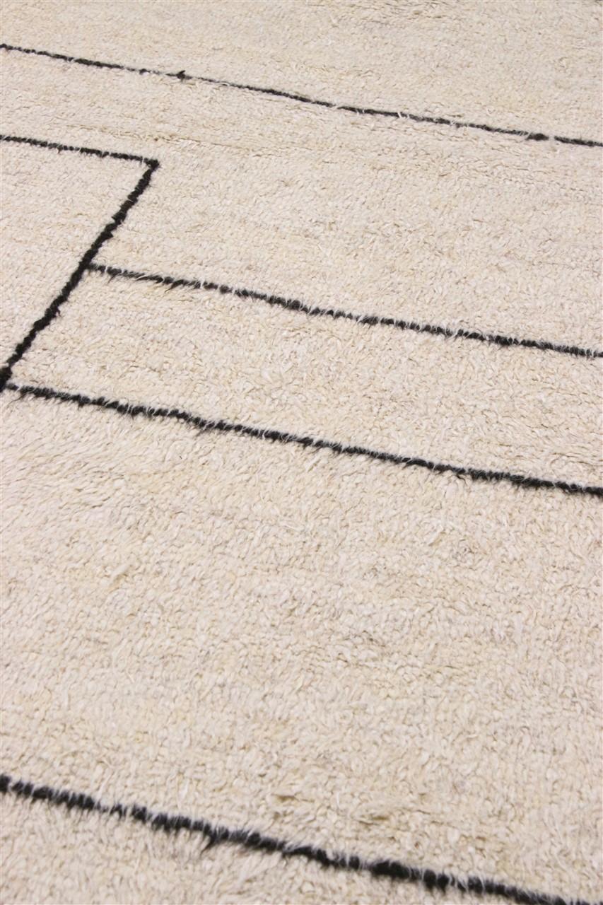 Et håndknyttet tæppe i Berber-stil fra Afghanistan med beige luv af uld og sorte minimalistiske linjer.