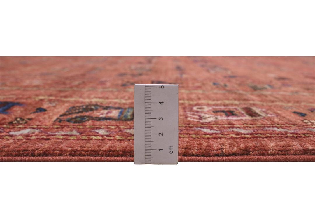 Een handgeknoopt tapijt uit het Midden-Oosten met een rood veld en tribale motieven