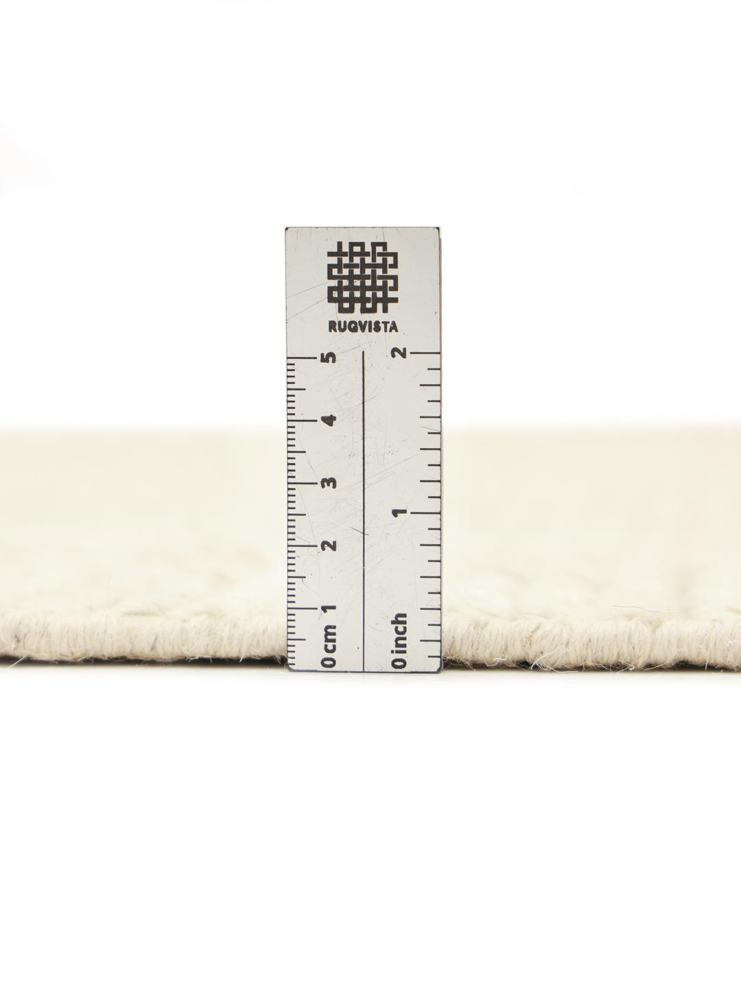 Håndknyttet afghansk tæppe med et geometrisk diamantmønster i beige.