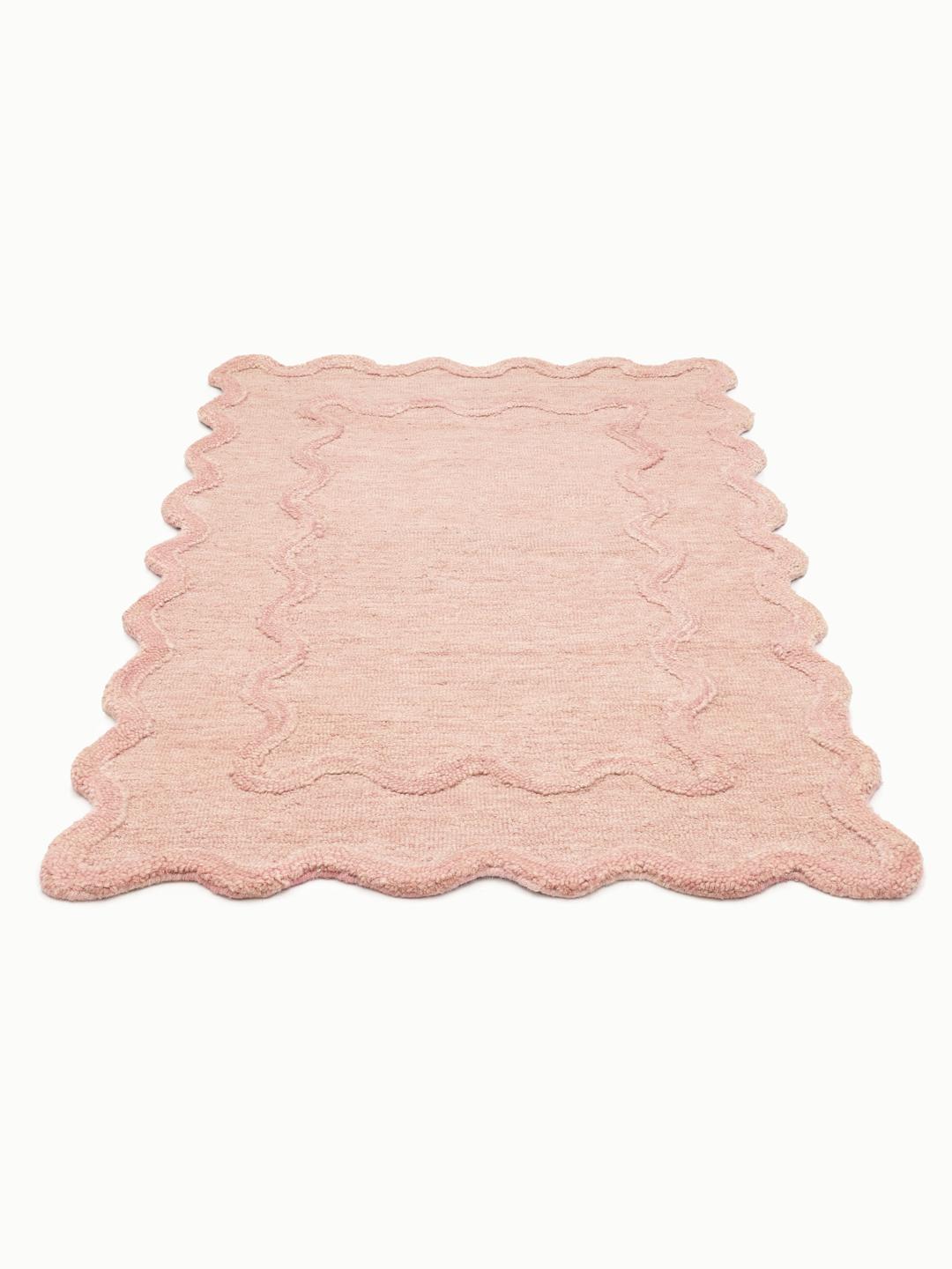 Roze tapijt met een geschulpte rand en getextureerde boord