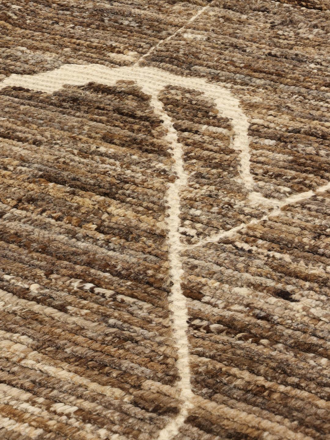 Un tapis afghan noué à la main présentant un motif géométrique dans des tons marron terreux.