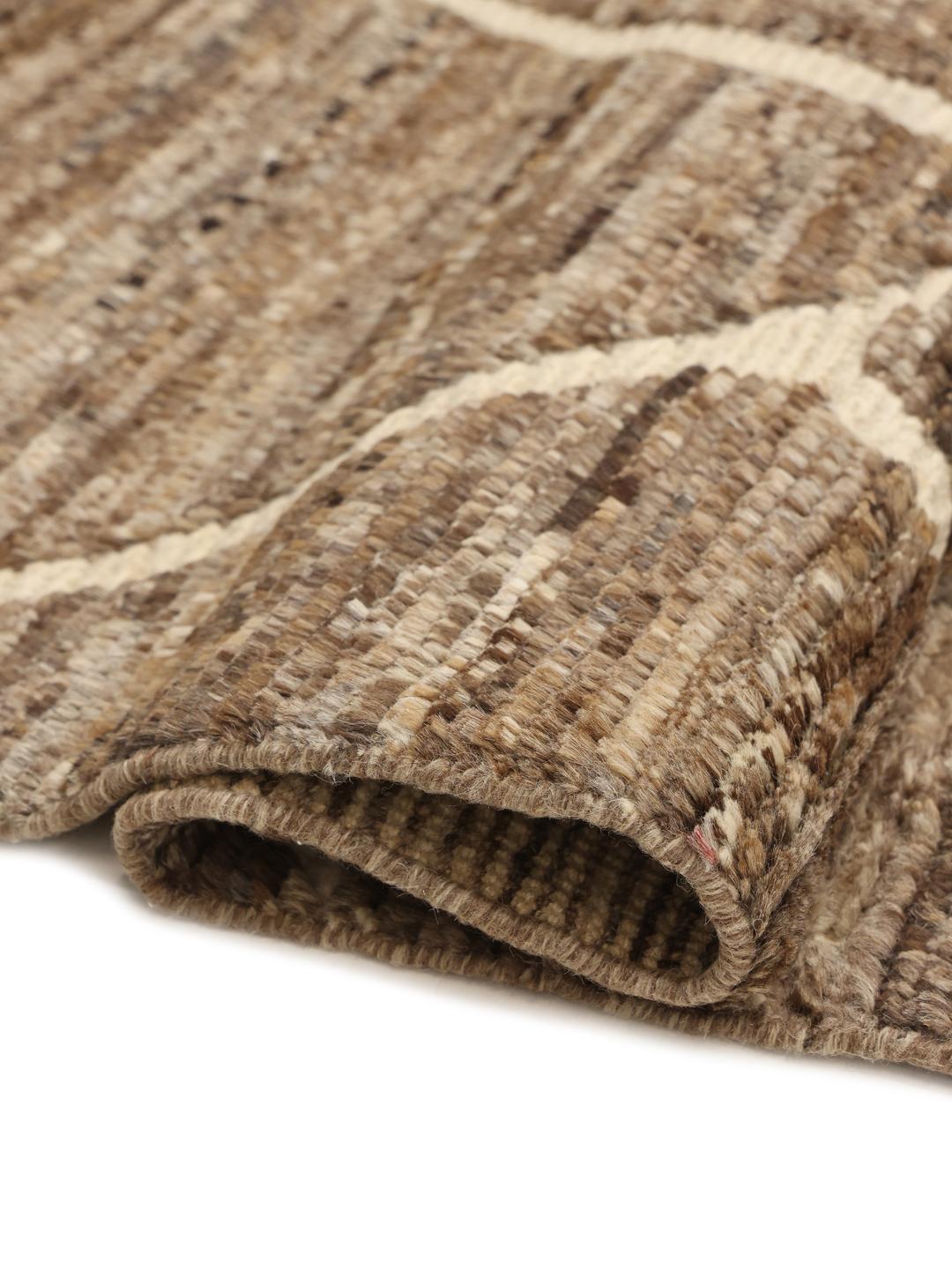 Un tapis afghan noué à la main présentant un motif géométrique dans des tons marron terreux.